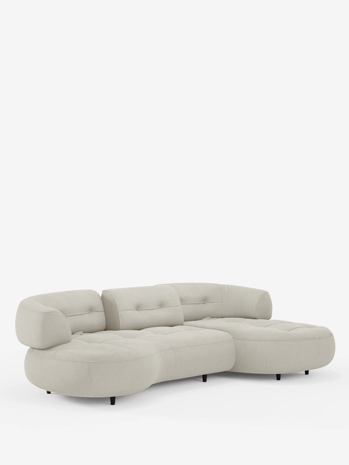 Il divano angolare Croissant, dal design a forma di fagiolo e con schienali scorrevoli in morbido tessuto effetto cotone lavabile T33, è un divano componibile curvo color beige chiaro, caratterizzato da una silhouette morbida a forma di fagiolo, cuscini trapuntati e gambe cilindriche scure.