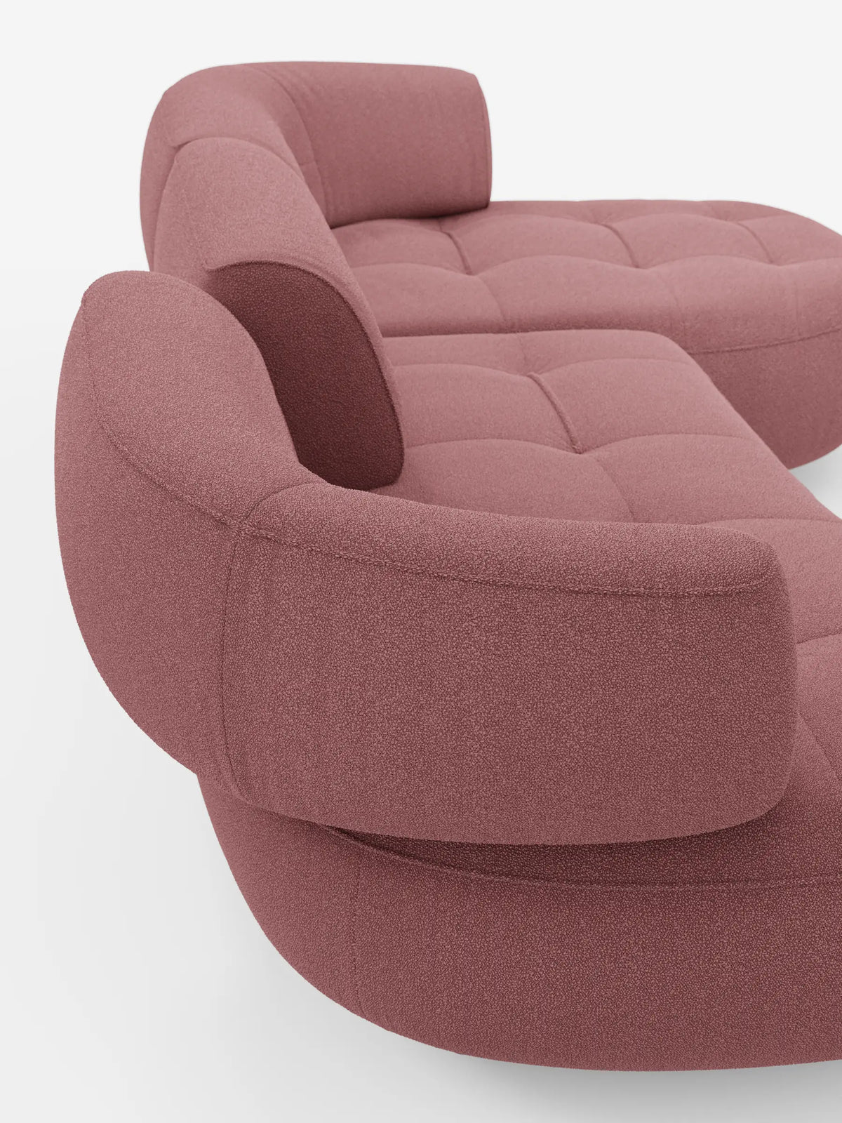 Un divano angolare Croissant dalla forma ricurva a fagiolo, con schienali regolabili in morbido tessuto effetto cotone smacchiabile T33 rivestito in rosa polveroso, caratterizzato da schienali arrotondati e regolabili e da una seduta trapuntata su fondo bianco.
