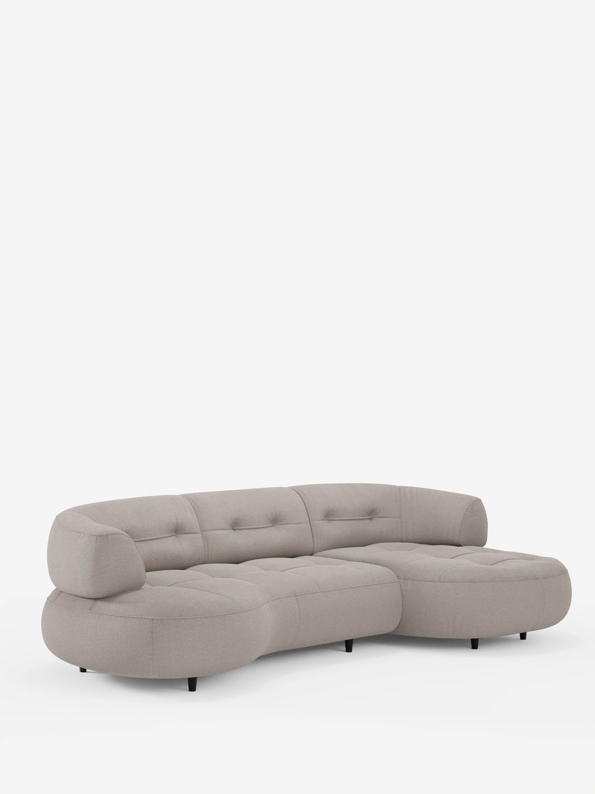 Un divano angolare Croissant color beige dal design a fagiolo e schienali scorrevoli, rivestito in morbido tessuto effetto cotone smacchiabile T33, caratterizzato da un design curvo e trapuntato su piccoli piedini neri su sfondo bianco, con un rivestimento morbido e dalla trama ricca.