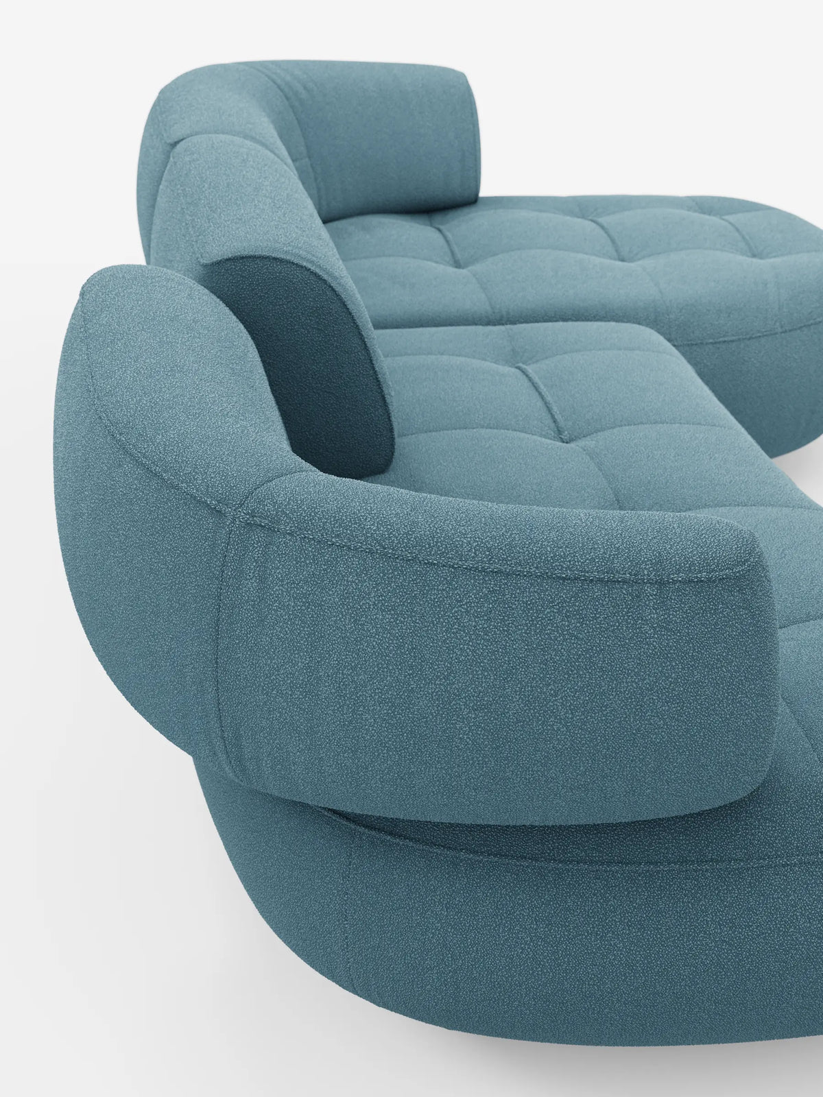 Un divano angolare Croissant di colore azzurro, dal design a forma di fagiolo e con schienali scorrevoli, rivestito in morbido tessuto effetto cotone smacchiabile T33, caratterizzato da curve arrotondate, seduta trapuntata e cuscini rimovibili su sfondo bianco.