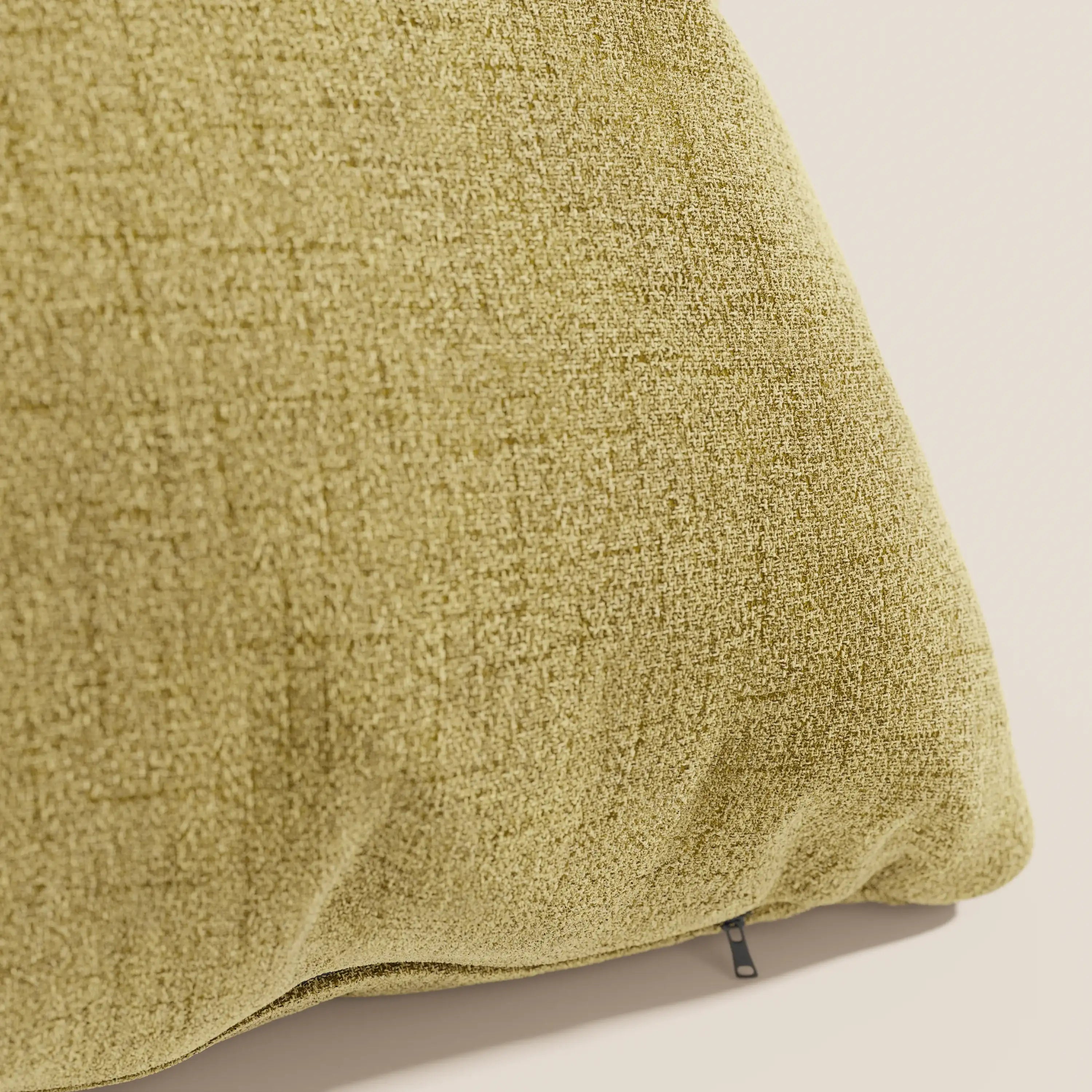 Primo piano del cuscino impermeabile Felis T03 giallo di Divani.Store, caratterizzato da un tessuto giallo morbido e strutturato con un piccolo tiretto nero sul bordo inferiore, su uno sfondo neutro.