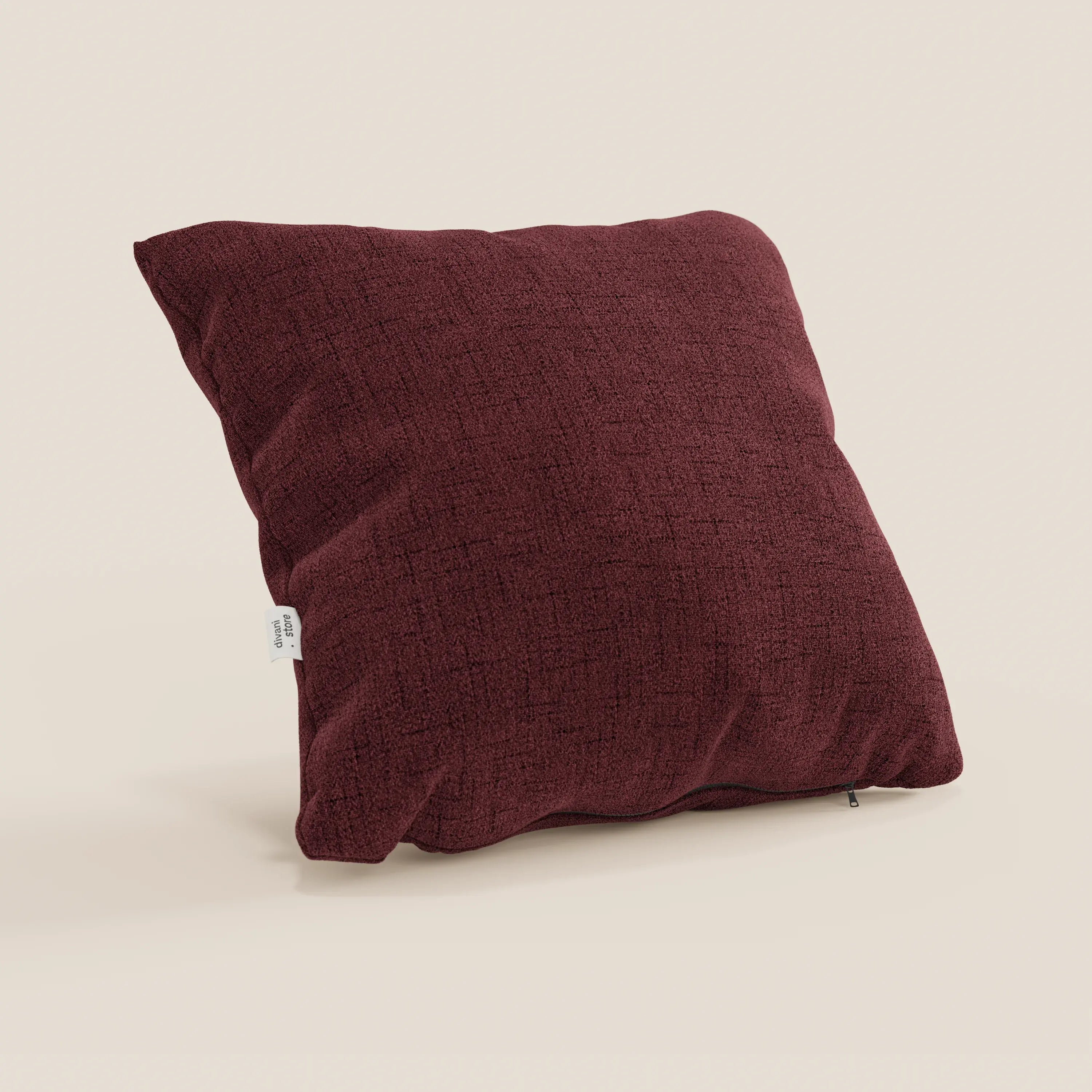 Il cuscino Felis cuscini by Divani.Store in rosso T03 è un cuscino quadrato di colore rosso scuro con una trama minimale, cuciture a vista, una piccola etichetta laterale bianca e una cerniera inferiore. Realizzato in morbido tessuto impermeabile, è posizionato in verticale su uno sfondo beige chiaro.