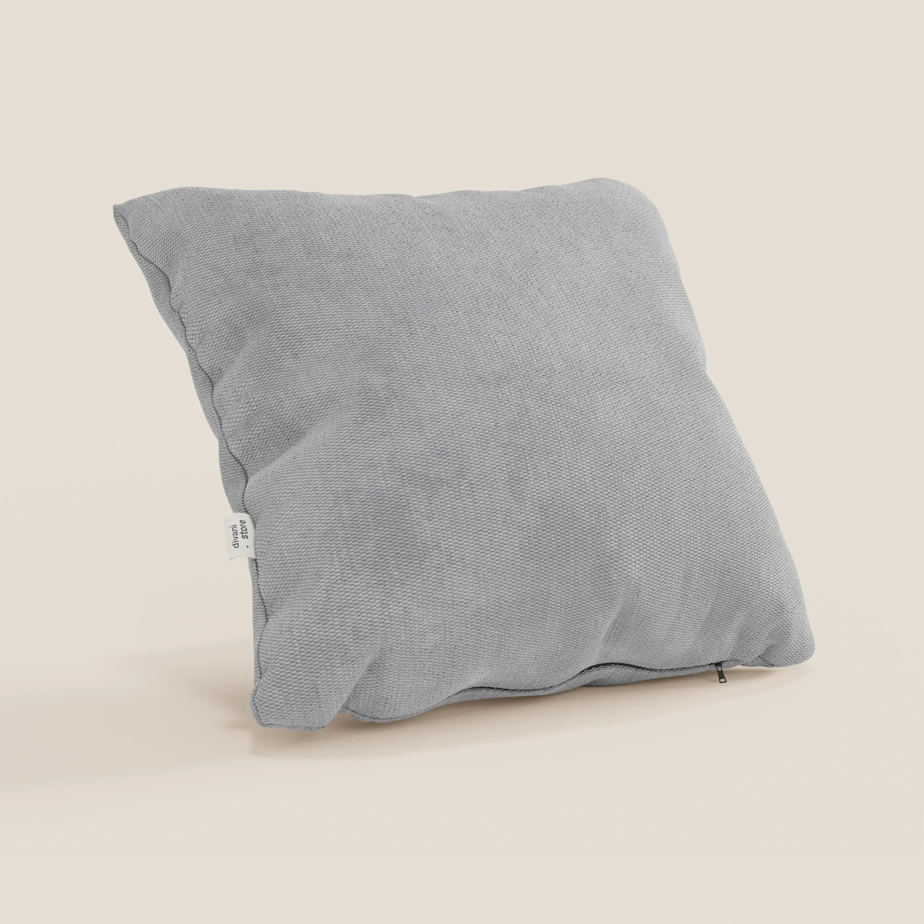 Il cuscino Miami di Divani.Store in T14 grigio chiaro è caratterizzato da un tessuto morbido e impermeabile e da un design squadrato, con una piccola etichetta bianca e un coperchio con cerniera per facilitare il lavaggio in lavatrice. È posizionato in verticale su uno sfondo bianco sporco.