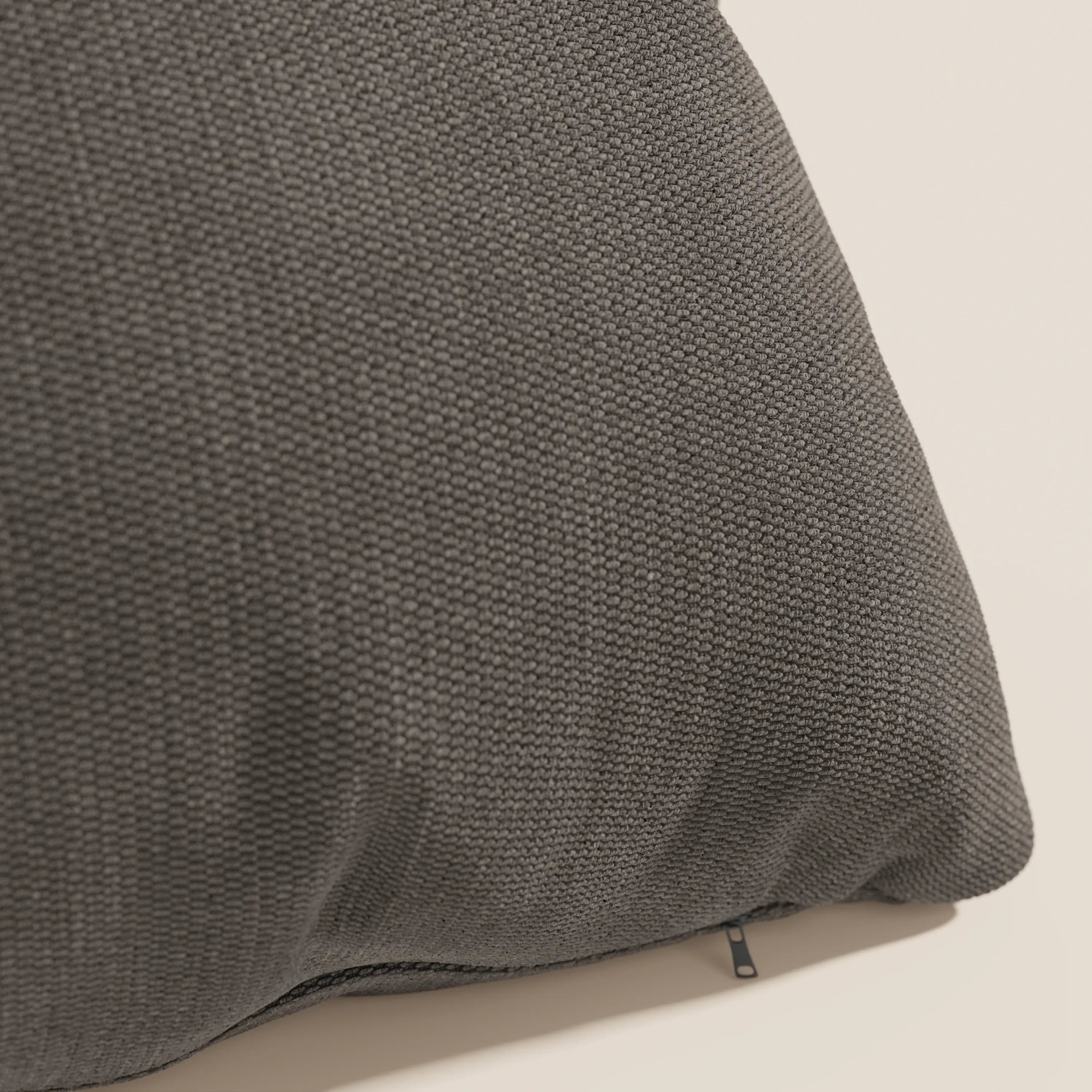 Primo piano del cuscino Miami 45x45 cm in tessuto morbido impermeabile T14 marrone di Divani.Store. Il tessuto a trama fitta, la fodera lavabile e il piccolo tiretto della cerniera sono evidenziati su uno sfondo chiaro.