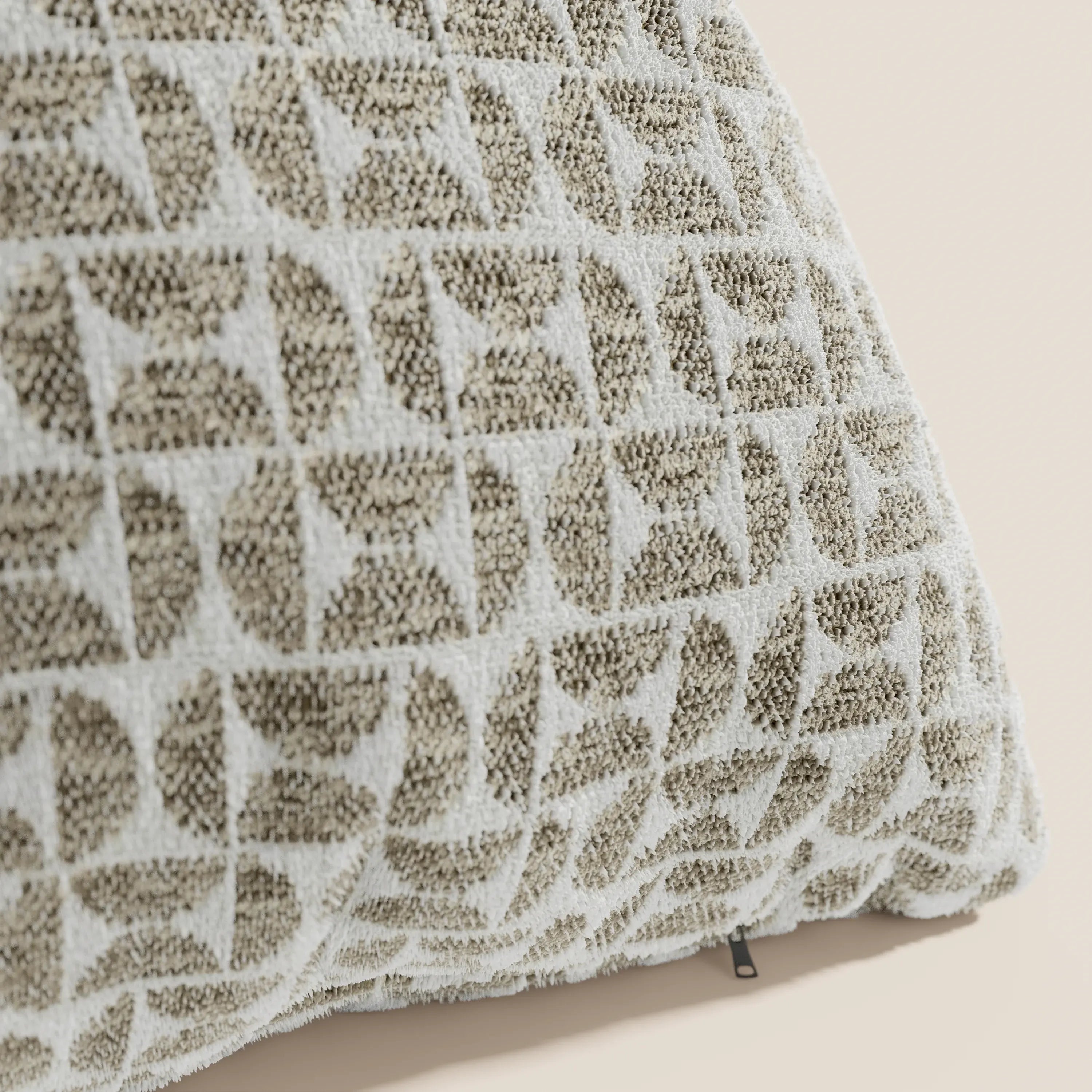 Primo piano del cuscino Naxos Decoro 45x45 in lino di Divani.Store, caratterizzato da un elegante motivo geometrico nei toni del beige e del bianco, composto da archi e quadrati intrecciati su uno sfondo tenue, con una piccola etichetta in tessuto sul bordo.