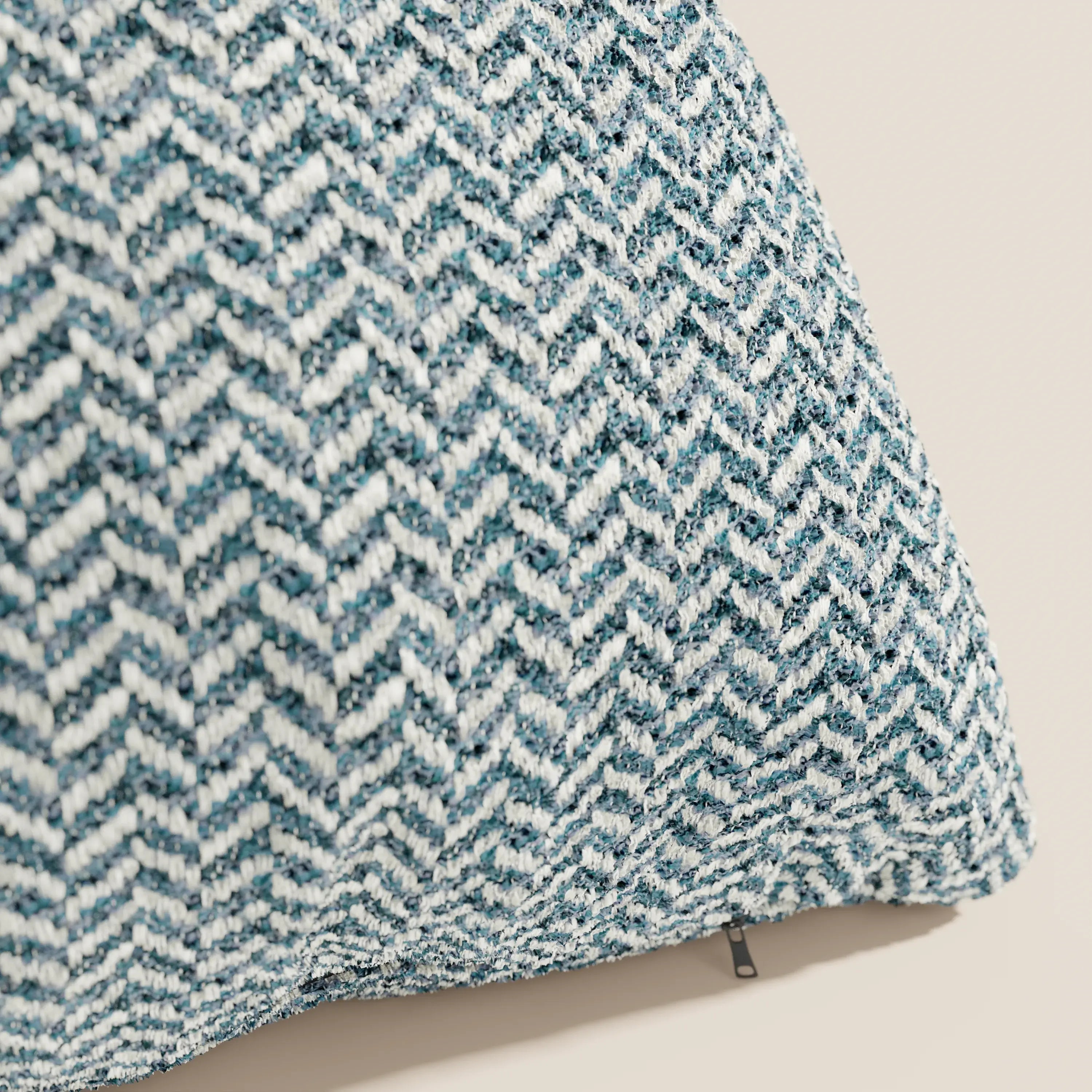 Primo piano del cuscino Sorrento 45x45 in lino di Divani.Store, realizzato in tessuto intrecciato con trama a rilievo e motivo a zig-zag nei toni del verde acqua e del bianco. È visibile una piccola cerniera. Fa parte della collezione di cuscini lavabili in lavatrice.