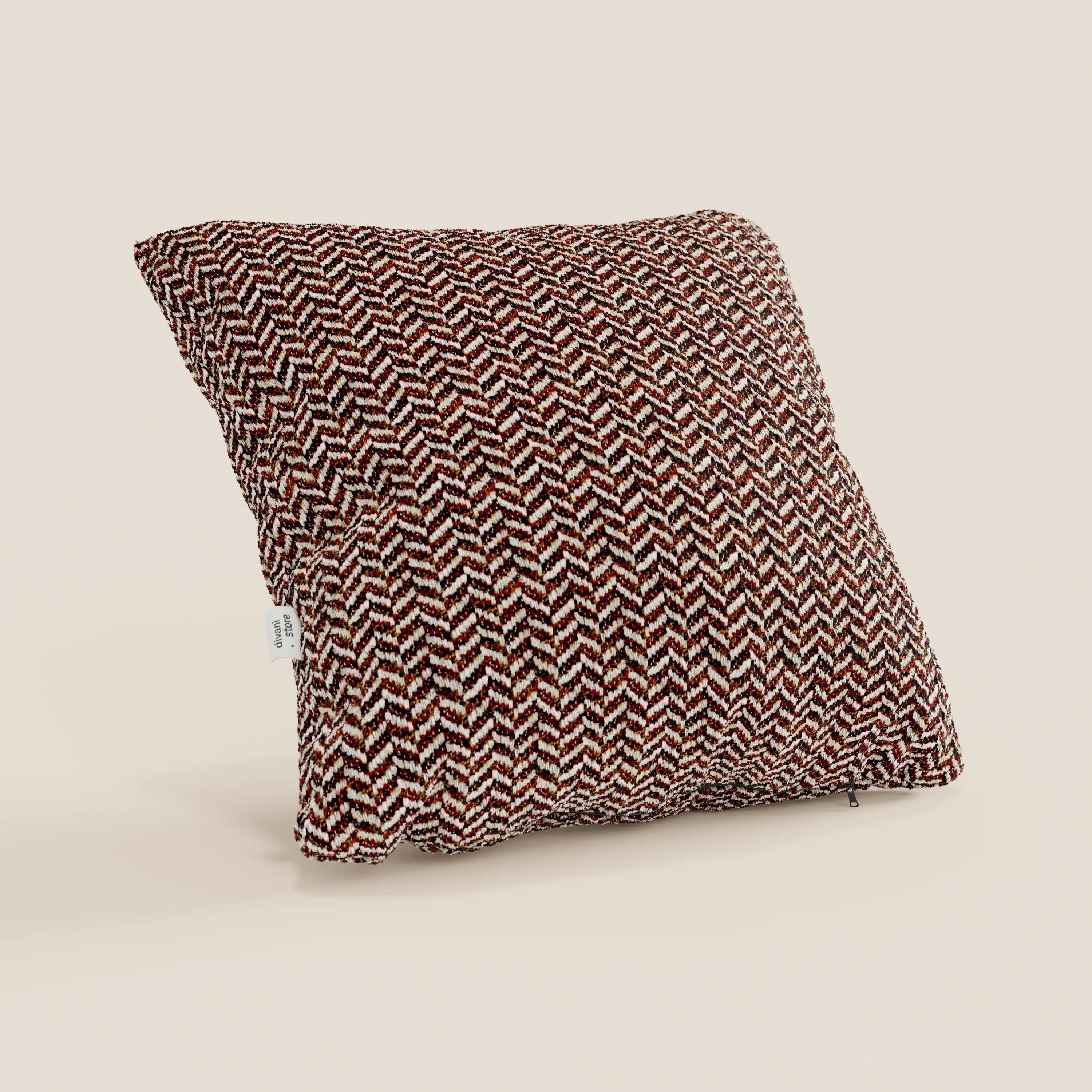 Il cuscino Sorrento 45x45 in lino di Divani.Store è un cuscino quadrato con un motivo a spina di pesce nei colori marrone, rosso e bianco, realizzato in morbido tessuto testurizzato con una piccola etichetta bianca sul lato, raffigurato in posizione verticale su uno sfondo neutro.