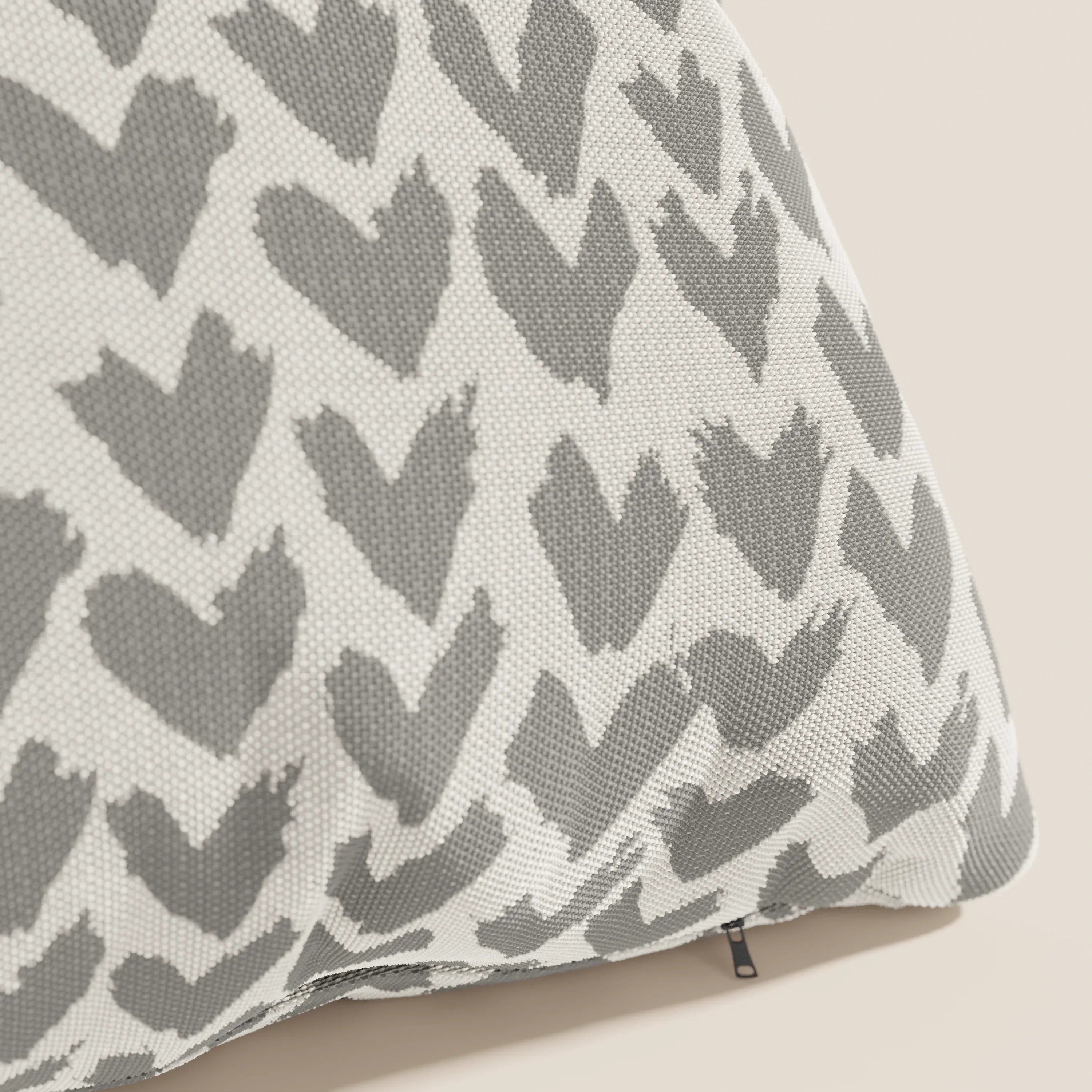 Primo piano di un cuscino geometrico Arrow di Divani.Store, con cuori grigi disegnati a mano su tessuto idrorepellente bianco con cerniera nera, ideale da abbinare ad altri cuscini geometrici colorati in un arredamento di stile.