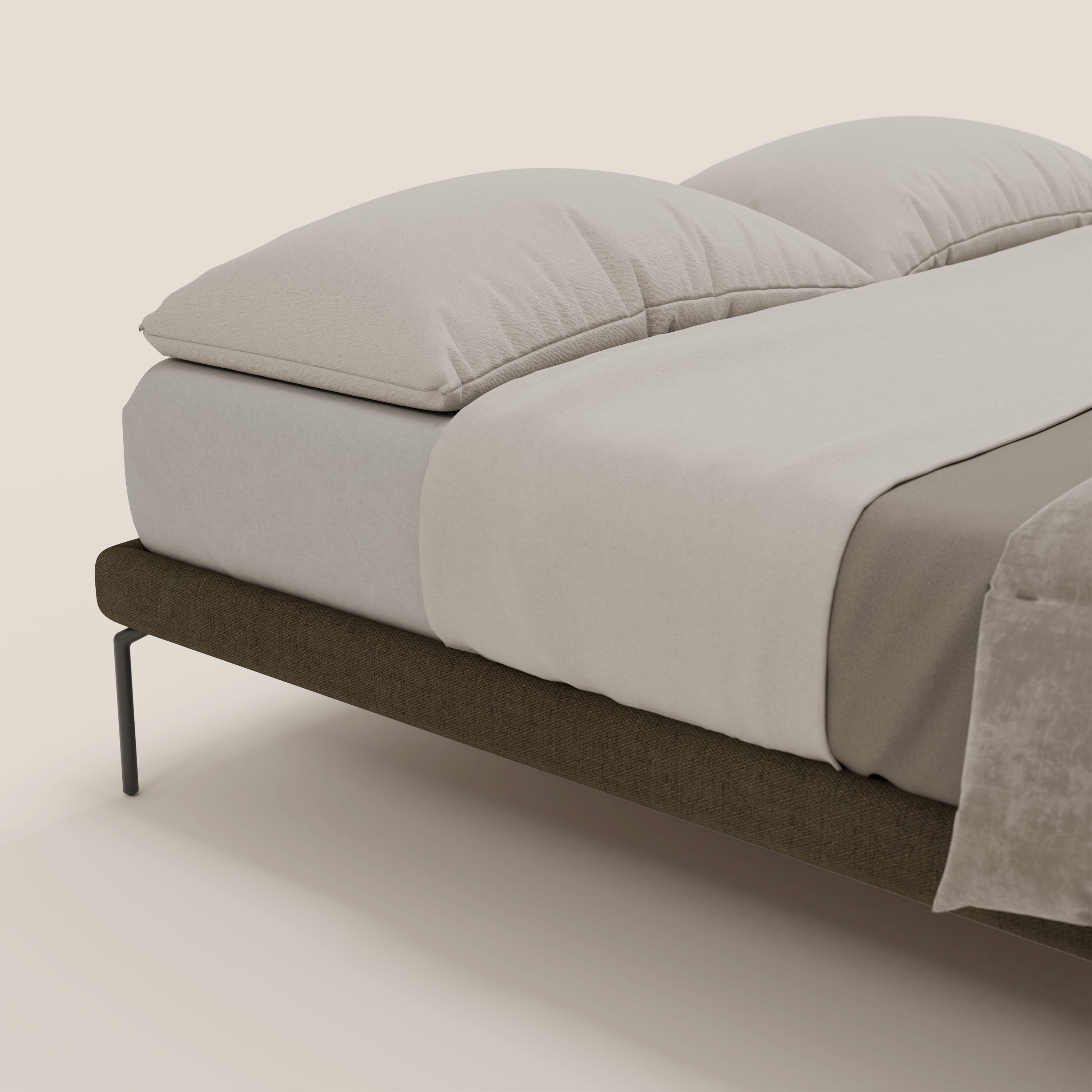 Il sommier sfoderabile Ring di Letti.store è caratterizzato da un tessuto impermeabile T14 marrone, da gambe alte 24 cm e da una struttura marrone scuro con biancheria da letto minimalista e due grandi cuscini, su uno sfondo neutro color crema per un look moderno.