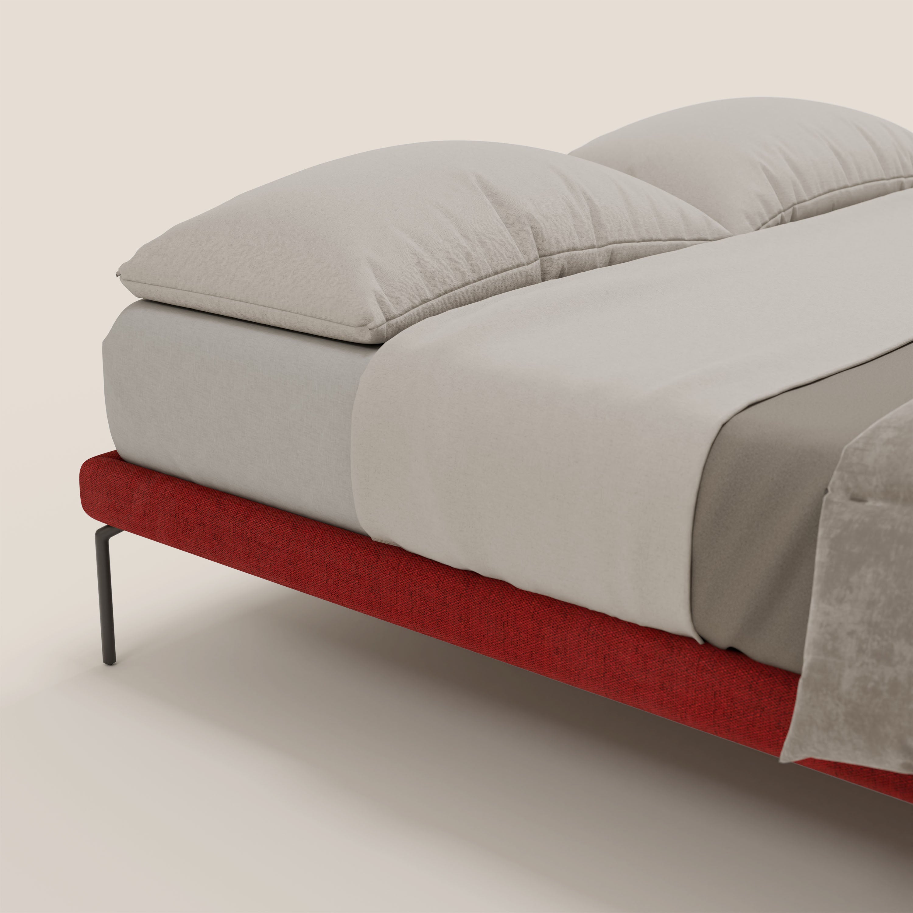 Primo piano del sommier sfoderabile Ring di Letti.store con gambe nere alte 24 cm in tessuto impermeabile rosso T14 e lenzuola beige chiaro, su sfondo bianco sporco. Spicca l'elegante design italiano.