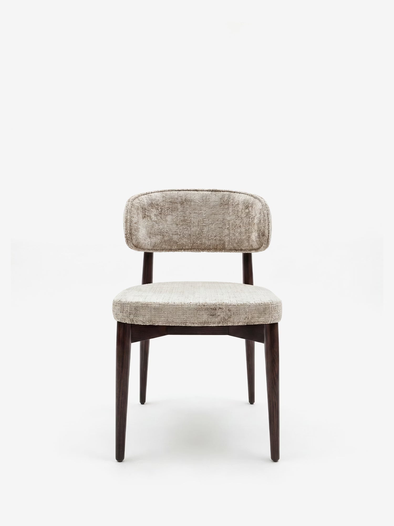 La sedia di design imbottita Dafne di Divani.Store è realizzata in ciniglia certificata OEKO-TEX® color beige chiaro e presenta uno schienale curvo, con sottili gambe in legno massello di wengé che le conferiscono un aspetto minimalista ed elegante.