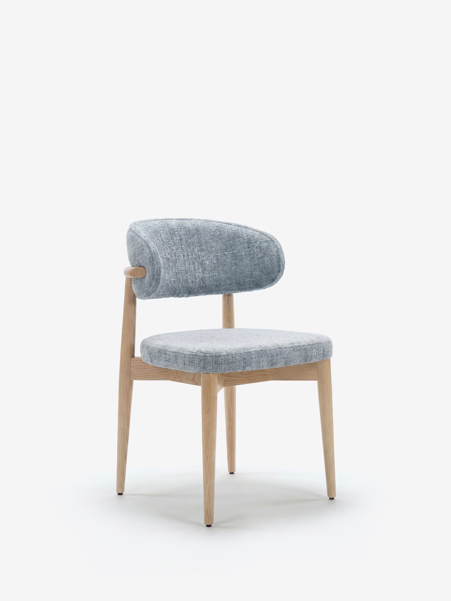 La sedia imbottita Dafne di Divani.Store si caratterizza per un design minimalista dalle curve morbide, gambe in legno massello di rovere chiaro e una seduta rivestita in ciniglia certificata OEKO-TEX® in grigio chiaro testurizzato.
