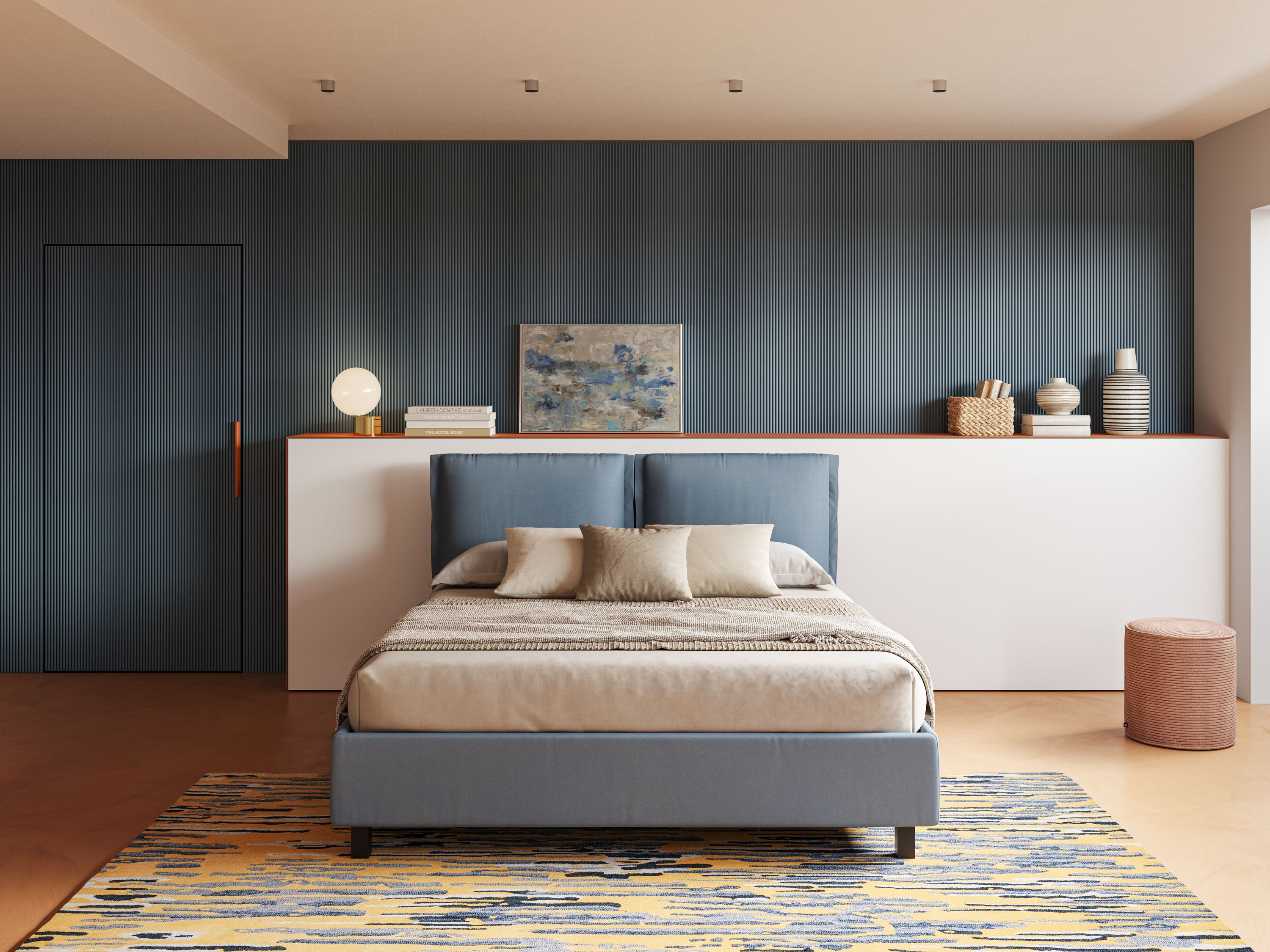 Una camera da letto moderna presenta il letto contenitore Emma con cuscini mobili in microfibra smacchiabile T11 carta da zucchero di Letti.store, vestito con biancheria da letto beige e blu, con una parete d'accento blu, una mensola decorativa bianca, opere d'arte, una lampada e un tappeto a fantasia.