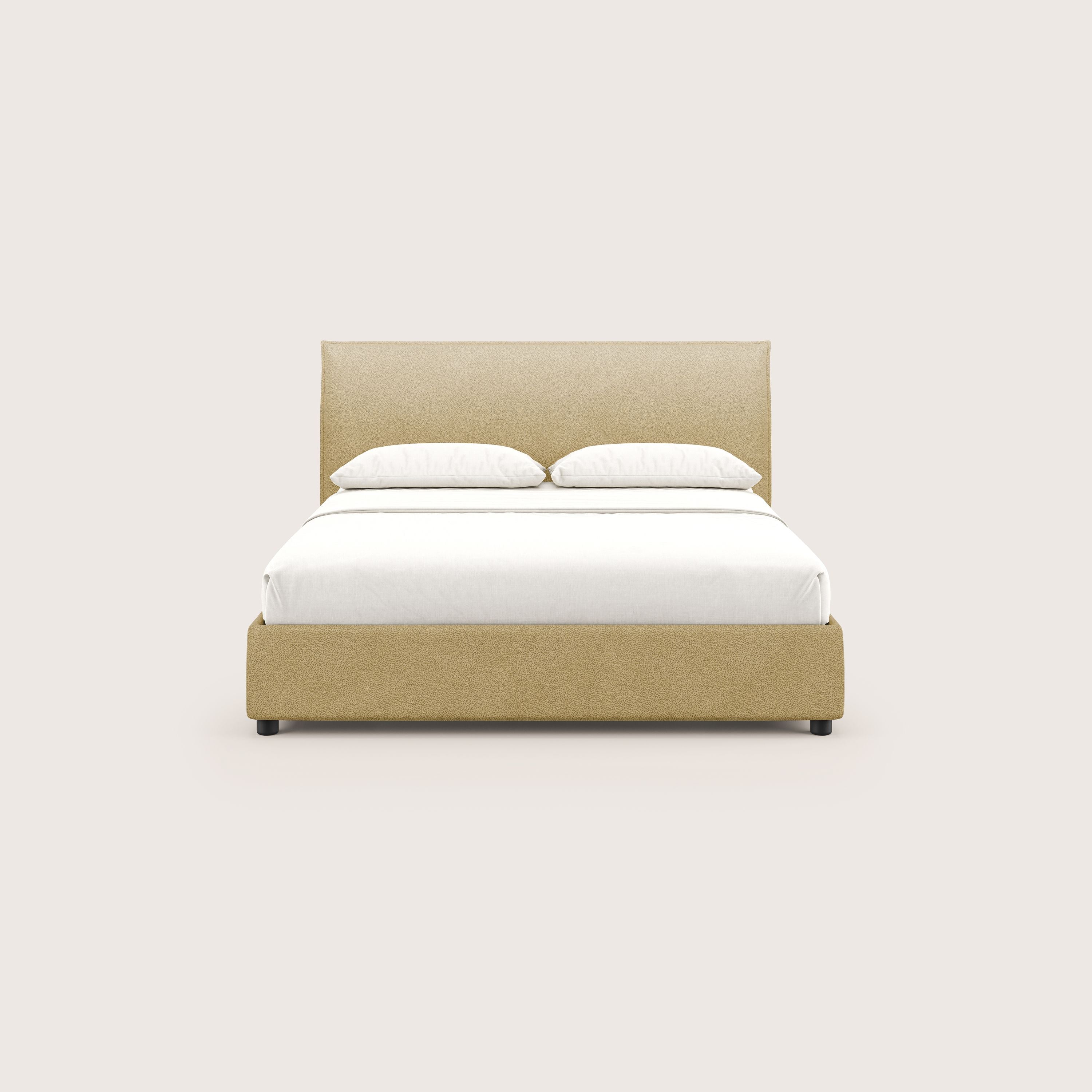 Il letto contenitore Nina di Letti.store, dal design minimale in microfibra gialla antimacchia, si staglia su uno sfondo a tinta unita. Il letto è realizzato in modo ordinato con biancheria bianca e due cuscini bianchi in testa.