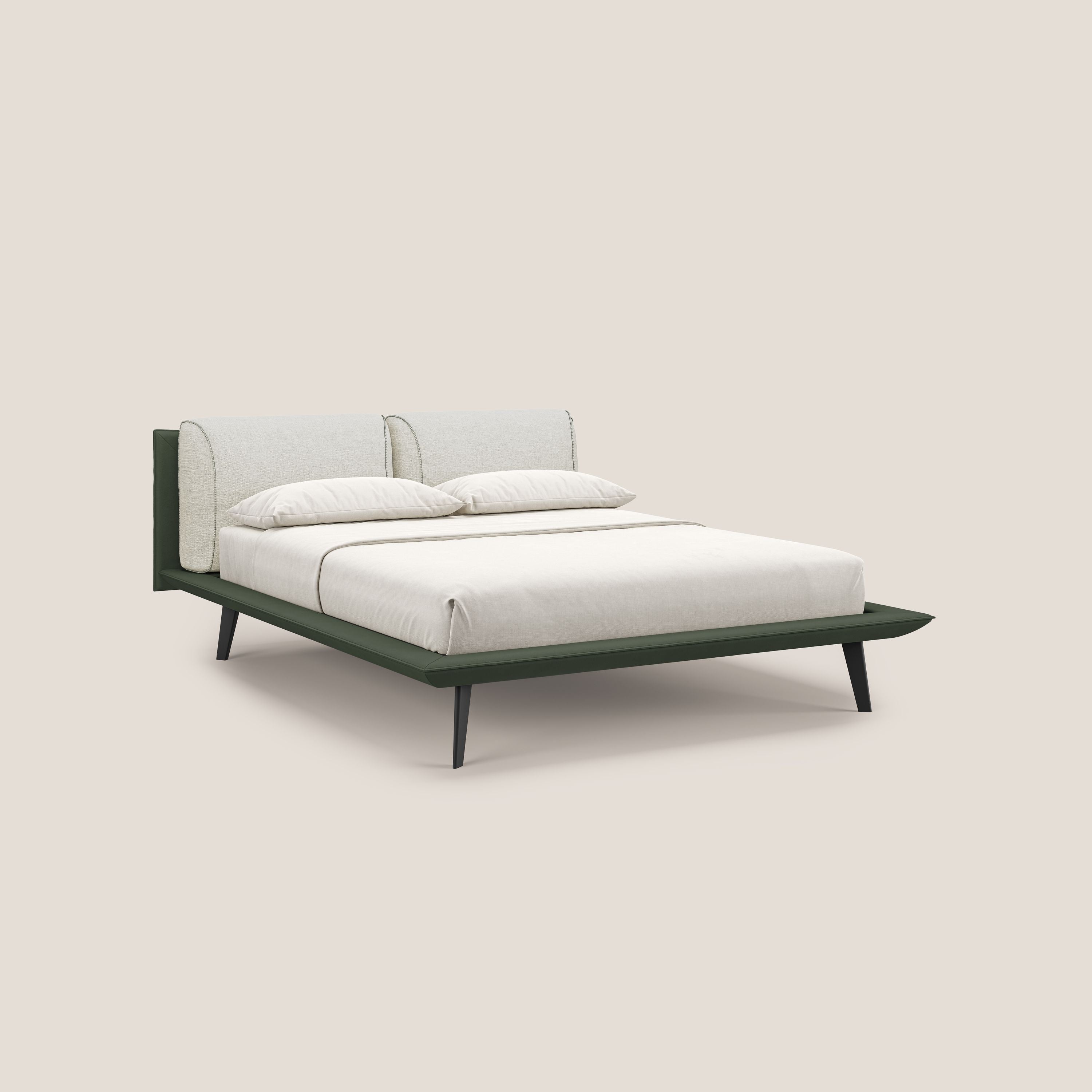 Petra di Letti.store: letto di design bicolore con cuscini in piuma, piedini in mogano e rivestimento impermeabile T11 verde e T06 panna. Il letto è ordinato con biancheria bianca e due cuscini, su sfondo beige.