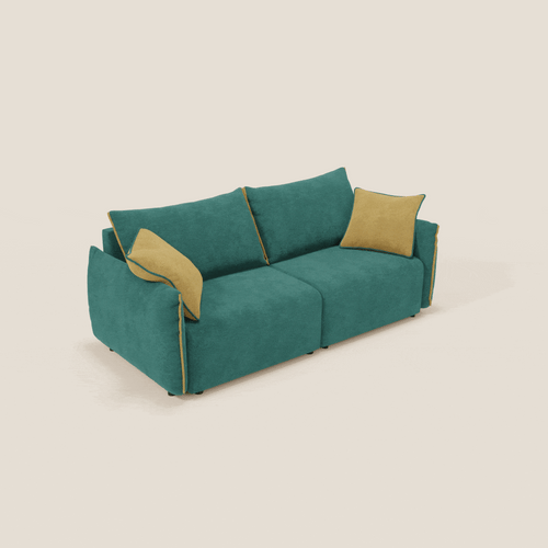 Il divano Flexar di Divani.Store è caratterizzato da sedute allungabili, schienali in piuma e un morbido rivestimento in bouclé verde-giallo impermeabile T07. Due cuscini d'accento gialli aggiungono un tocco di colore ai grandi cuscini verdi su sfondo beige chiaro.