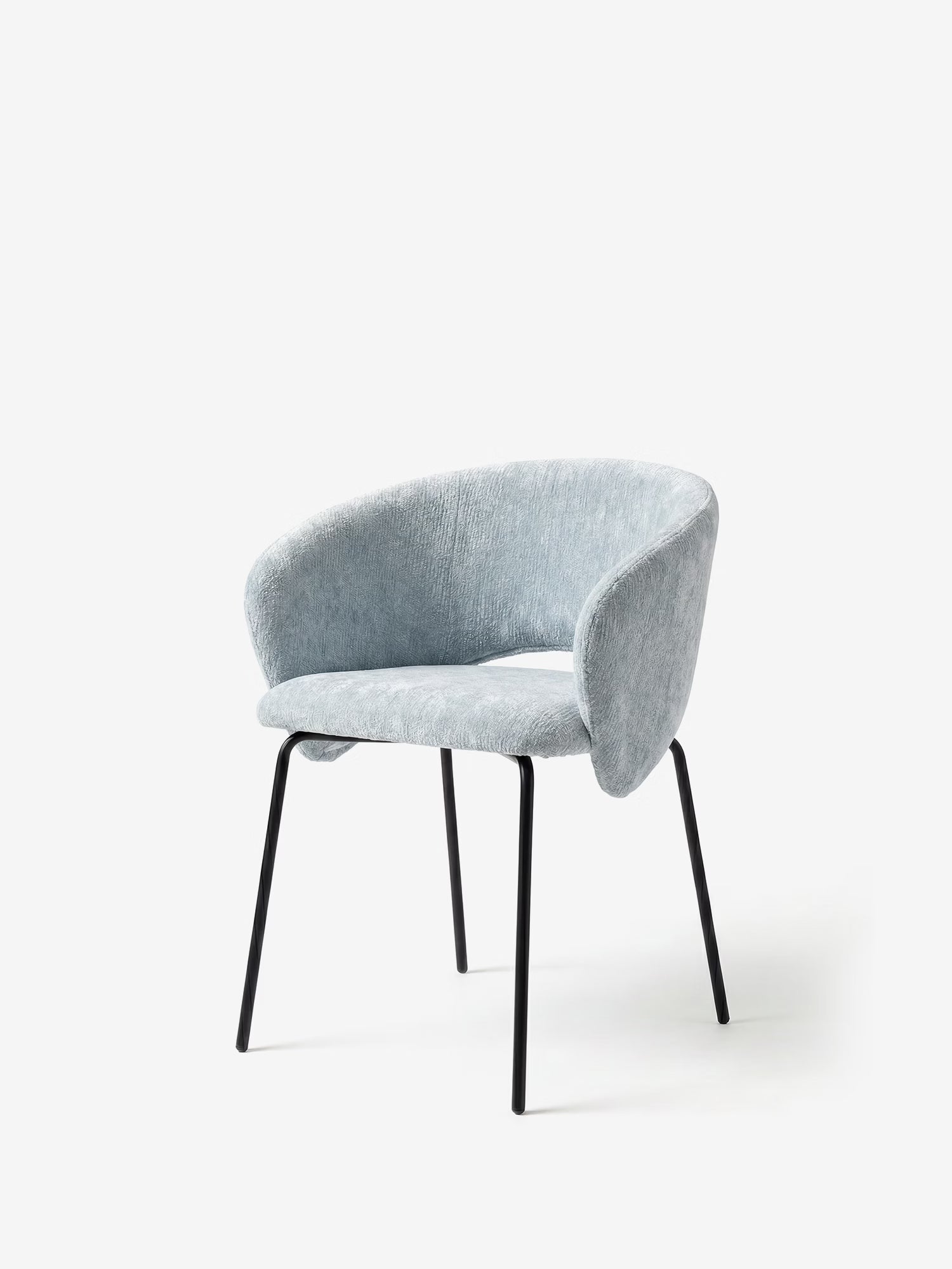 La sedia imbottita Fosca di Divani.Store presenta una seduta ricurva e braccioli in tessuto grigio chiaro certificato OEKO-TEX®, con sottili gambe in metallo nero, per un design minimalista e contemporaneo, perfetto per gli interni moderni.