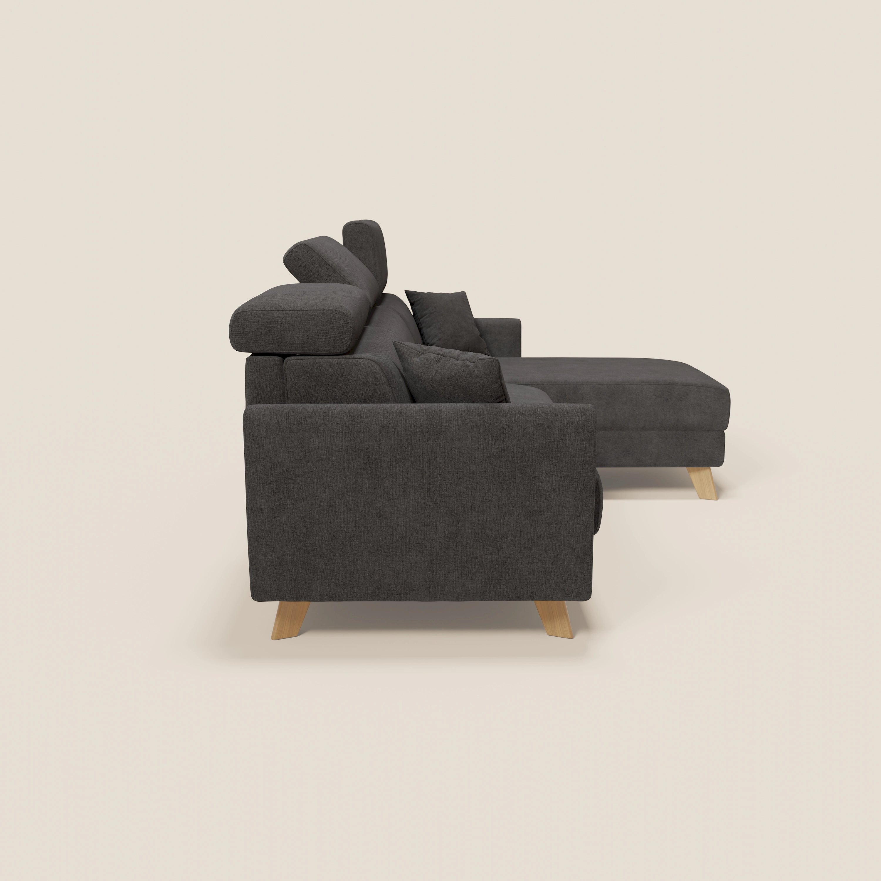 Il divano letto angolare sfoderabile Francy di Divani.Store in tessuto T17 antracite è caratterizzato da una chaise longue destra, poggiatesta reclinabili e gambe in legno chiaro per un comfort in stile nordico, presentato con cuscini scuri abbinati.