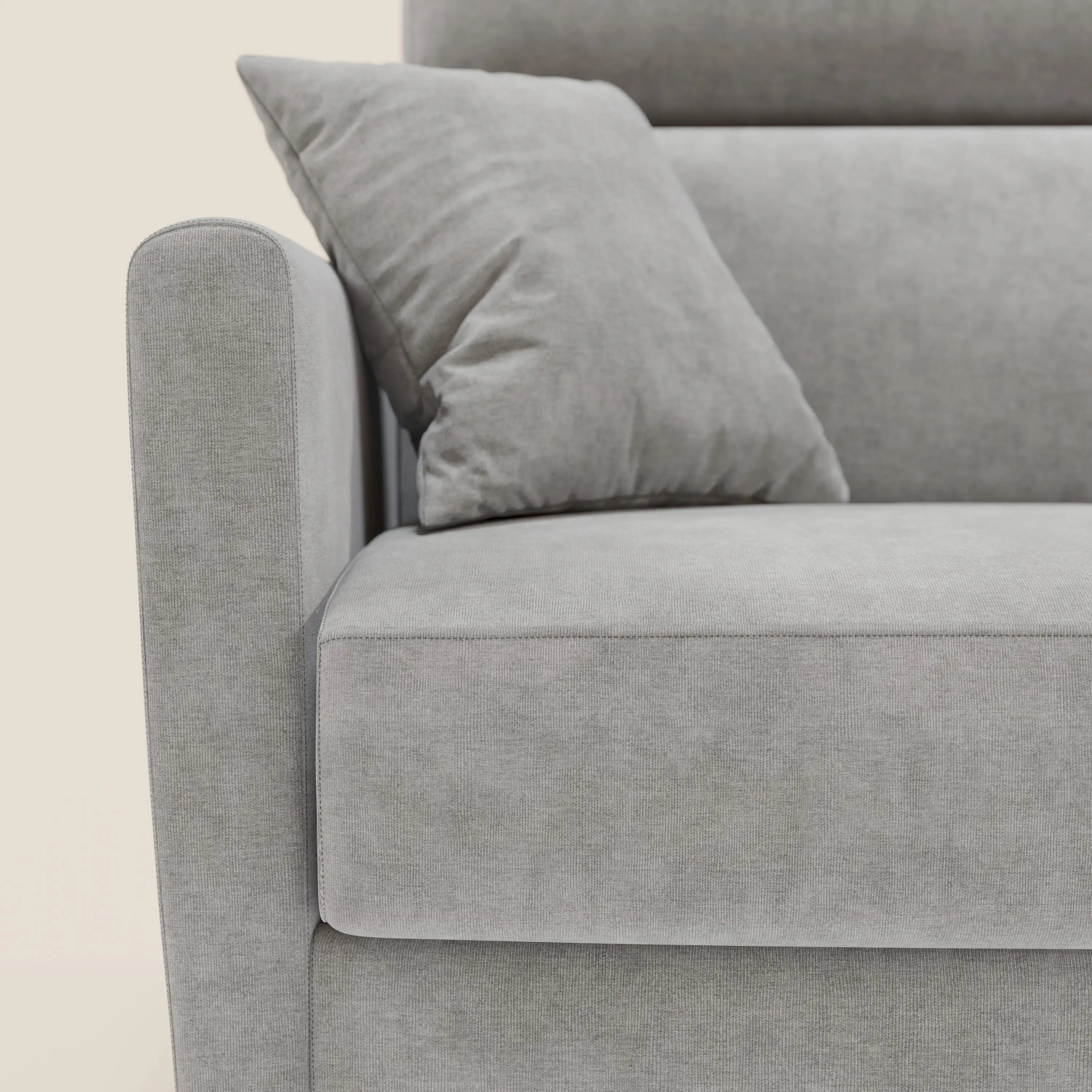 Primo piano del divano letto angolare Francy sfoderabile di Divani.Store in tessuto smacchiabile T17 grigio, con cuscino coordinato, penisola contenitore e poggiatesta reclinabile per un look pulito e moderno di ispirazione nordica.