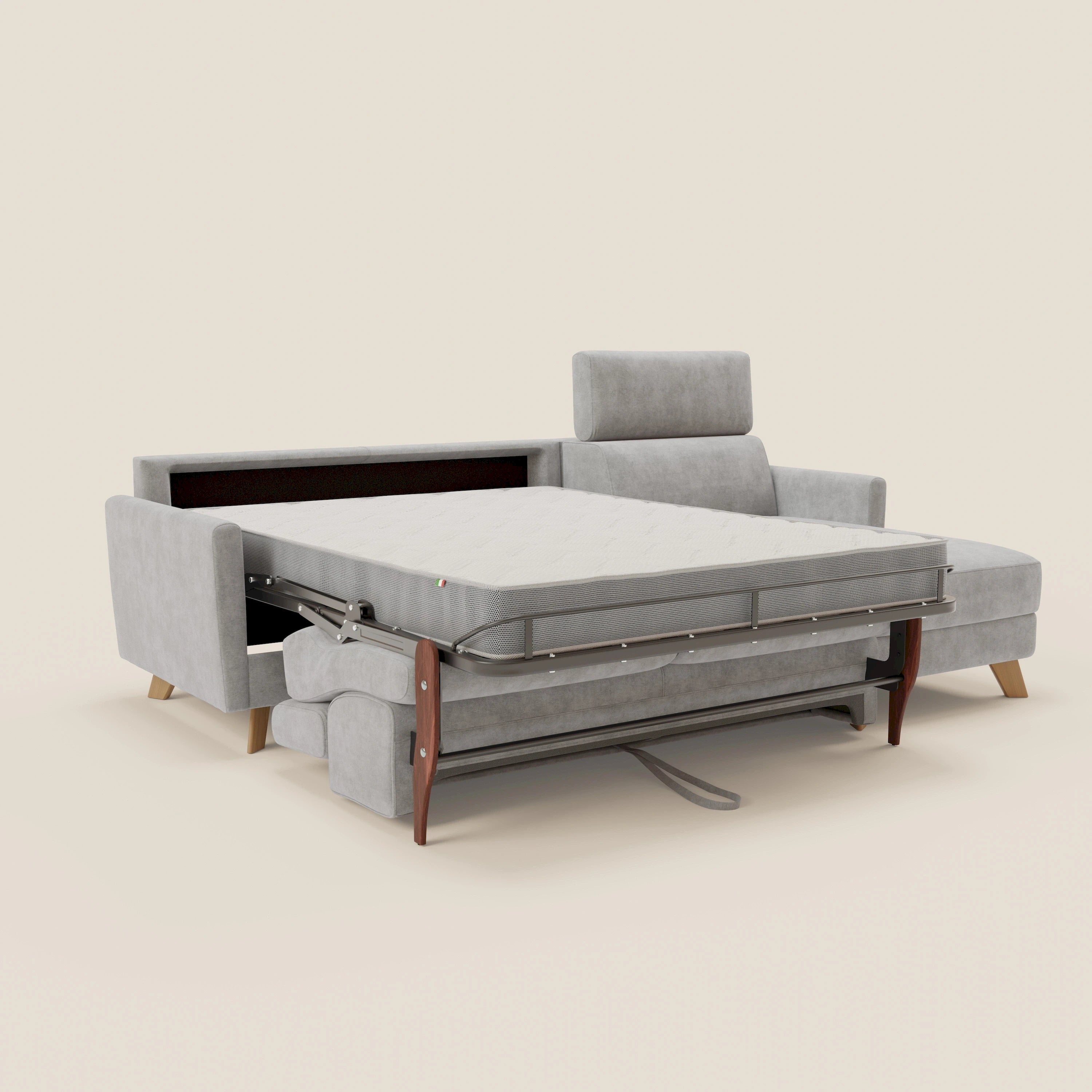 Il divano letto angolare sfoderabile Francy di Divani.Store in T17 grigio è presentato con letto estraibile esteso, struttura in metallo a vista, poggiatesta destro rialzato, gambe in legno e sfondo neutro. Le caratteristiche includono i poggiatesta reclinabili e la poltrona contenitore.