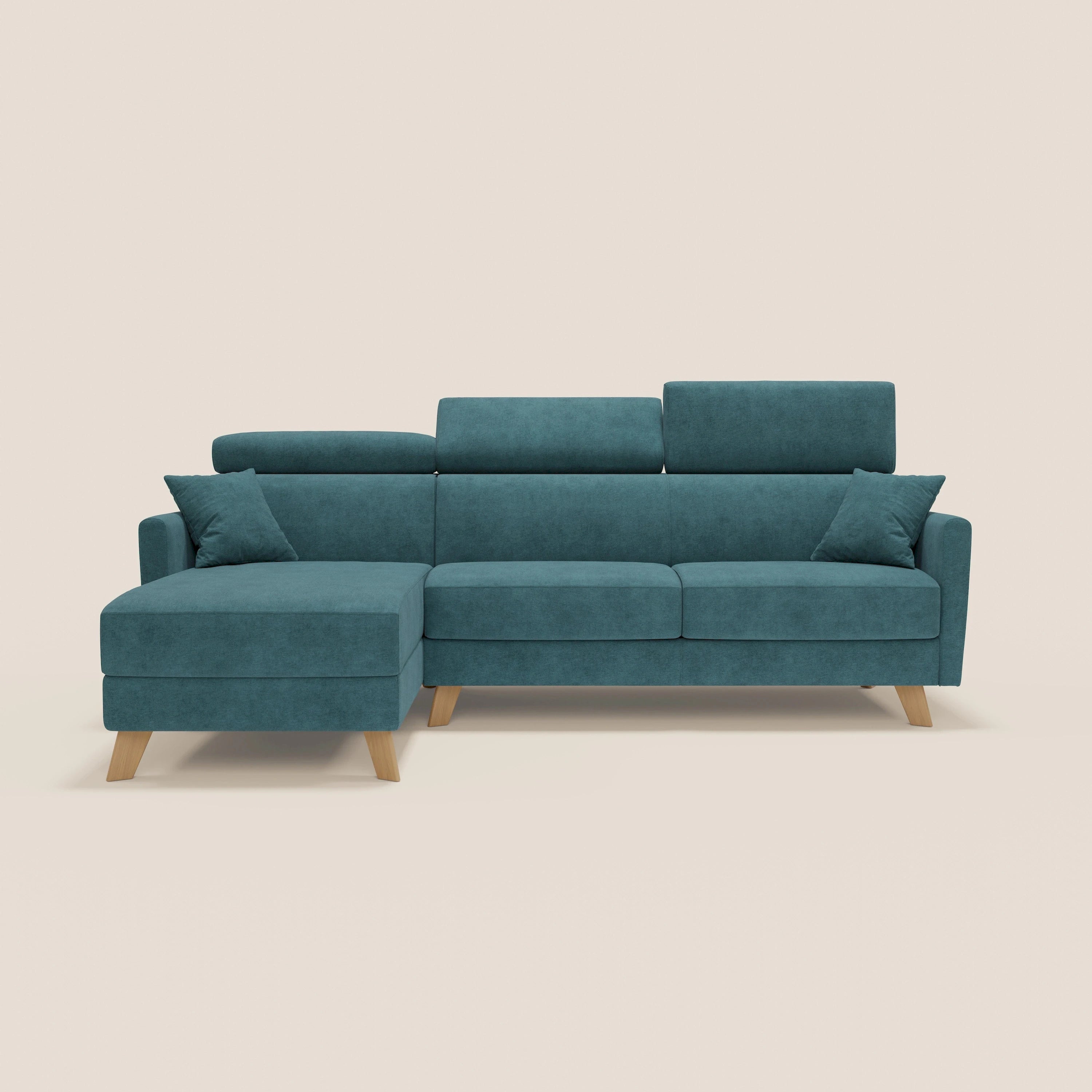 Il divano letto angolare sfoderabile Francy di Divani.Store, in tessuto smacchiabile T17 petrolio, è caratterizzato da una chaise longue sinistra con contenitore, poggiatesta reclinabili, gambe in legno, tre cuscini di schienale e due cuscini coordinati su sfondo beige.