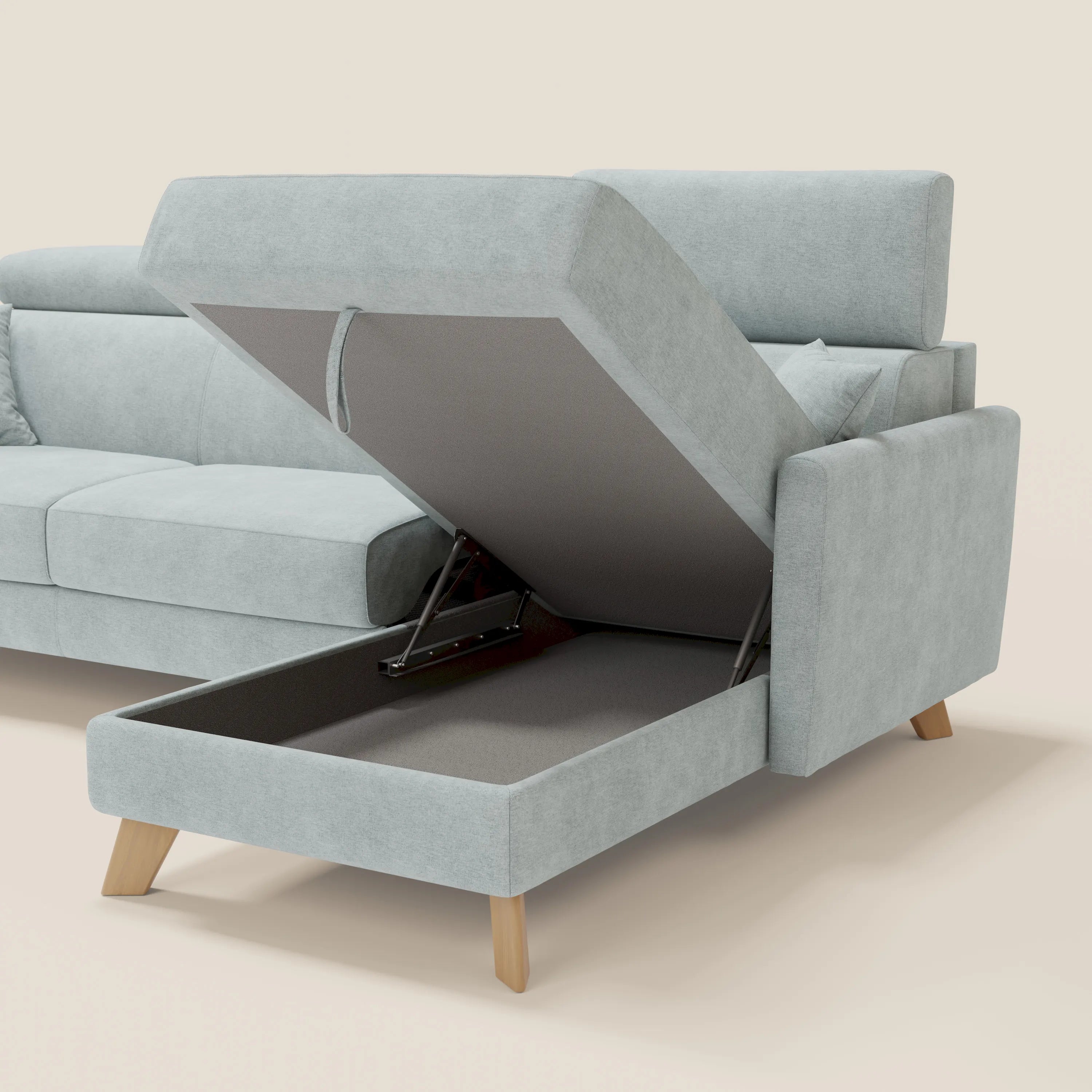 Il divano letto angolare sfoderabile Francy di Divani.Store è dotato di un vano contenitore con chaise longue sollevabile e di poggiatesta regolabili in tessuto T17 verde acqua, facile da pulire. Lo sfondo è in tinta unita beige.