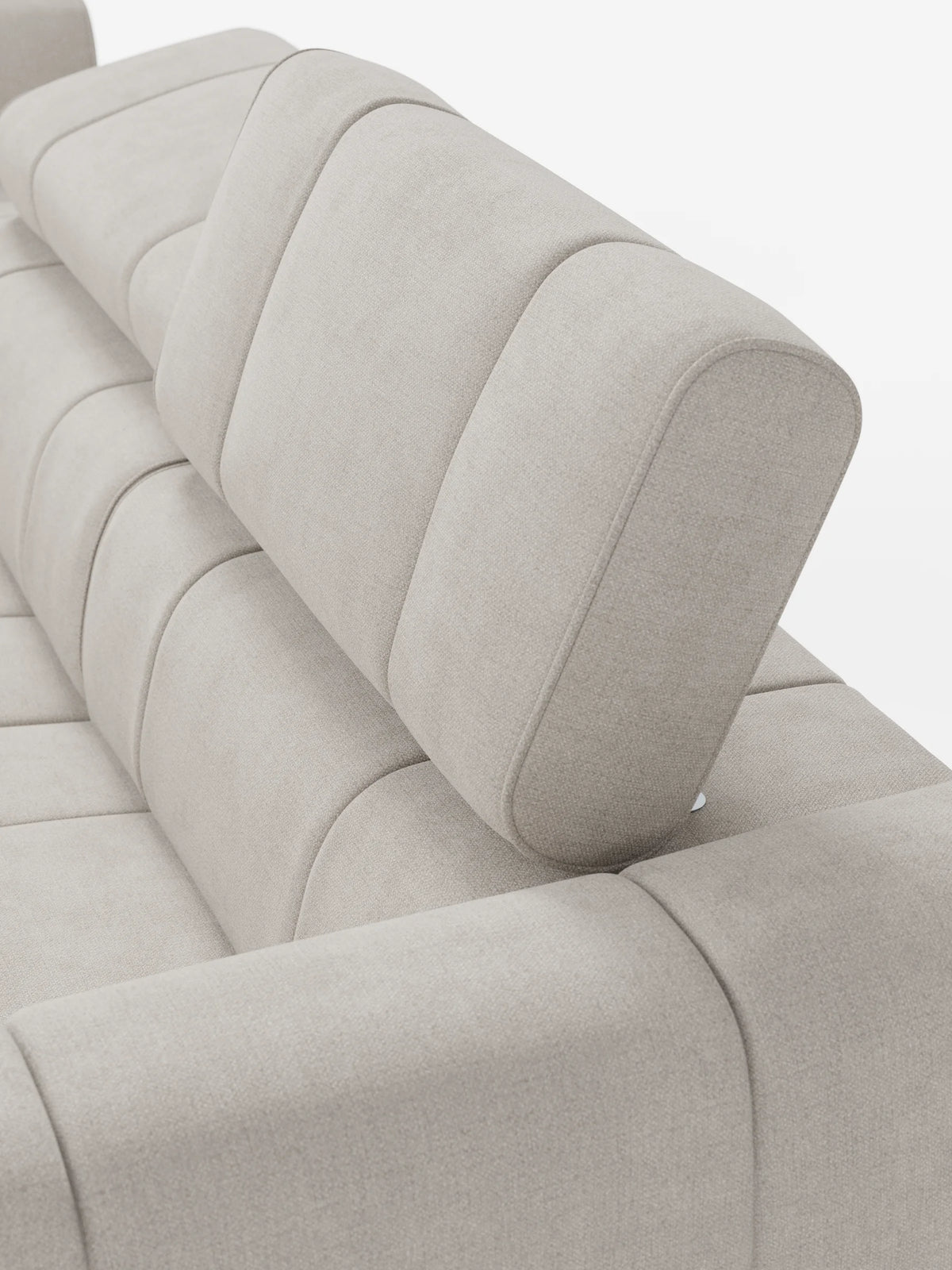 Un primo piano del divano componibile Giotto, color beige chiaro, con terminale aperto – opzione relax elettrico in tessuto smacchiabile T23, caratterizzato da cuscini dello schienale segmentati e da un poggiatesta regolabile dalle linee minimaliste su sfondo bianco.