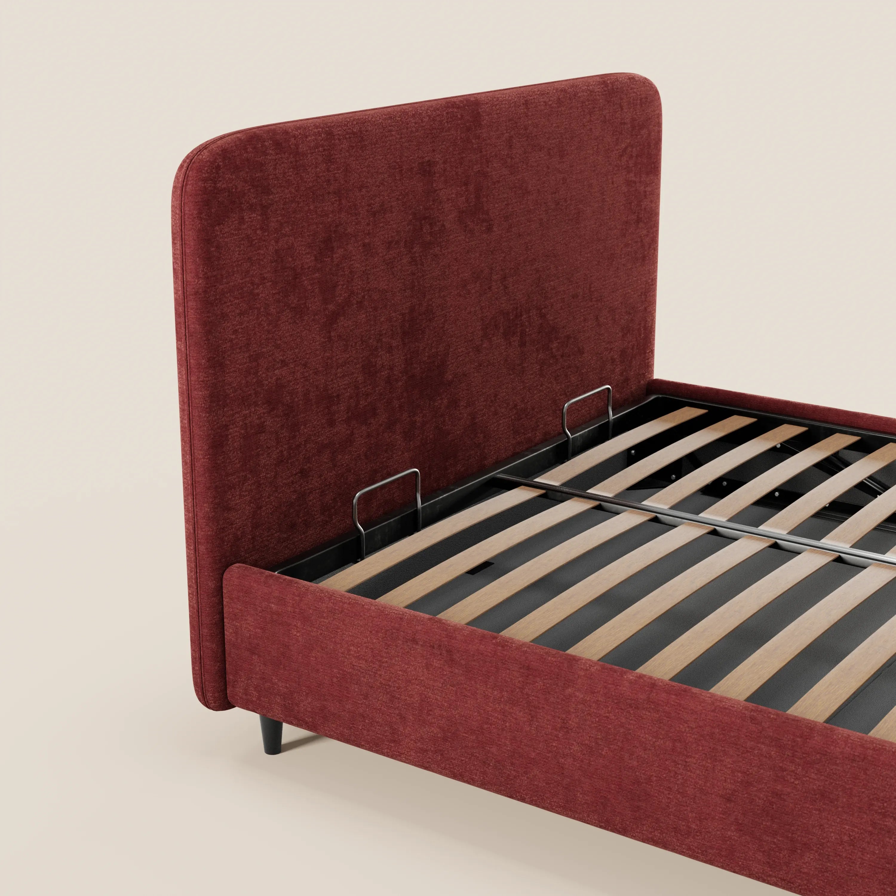 Il letto imbottito KAELOS minimal di Letti.store presenta una struttura rivestita in ciniglia rosso intenso e una testiera arrotondata, gambe alte nere, due aste di sostegno in metallo nero, doghe in legno a vista e un vano contenitore. Sfondo bianco sporco a tinta unita.
