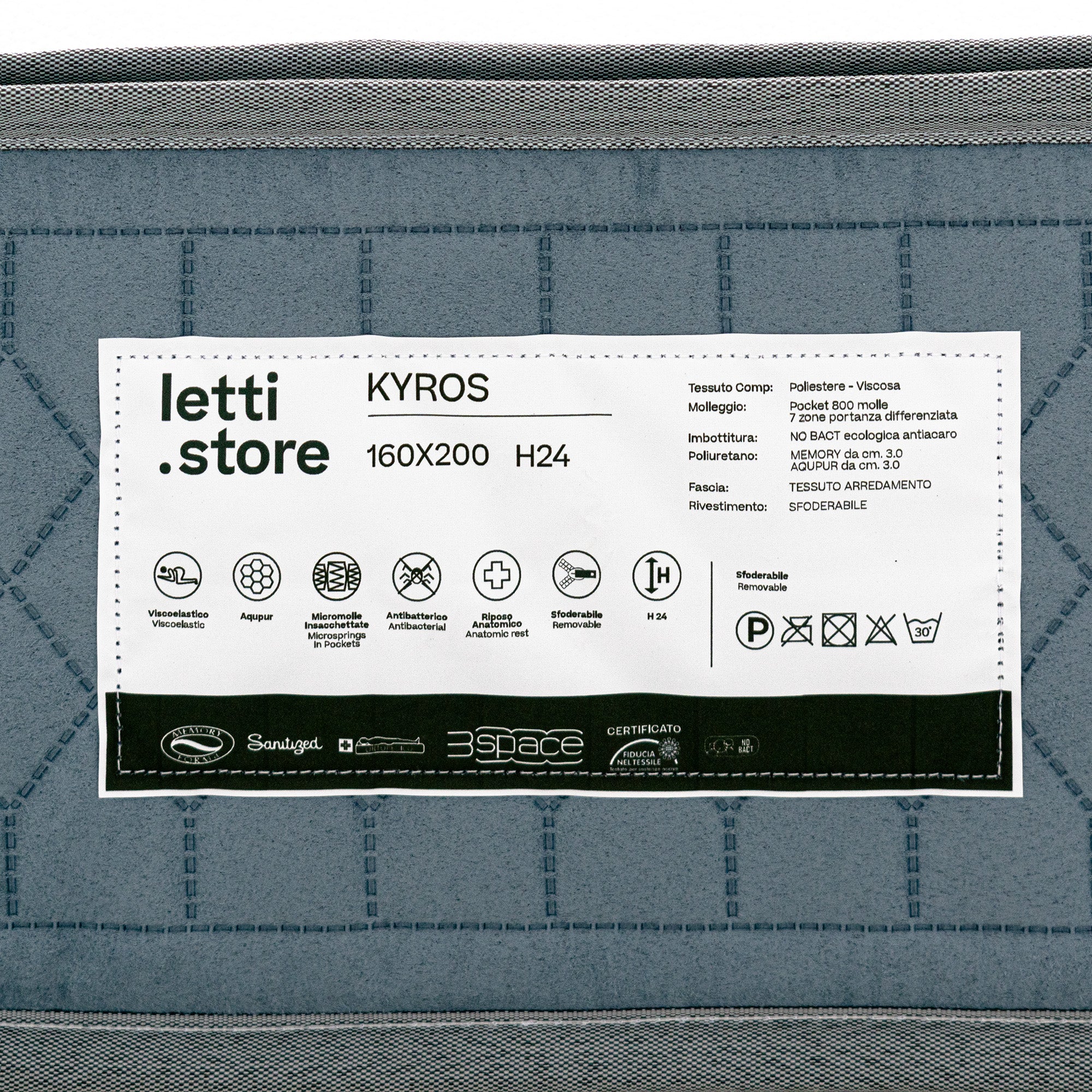Primo piano dell'etichetta grigia del KYROS - Materasso Luxury di Divani.Store, 160x200 cm, h 24 cm, con micro-molle insacchettate e supporto posturale a 7 zone su tessuto trapuntato, oltre a dettagli sul materiale e loghi di certificazione.