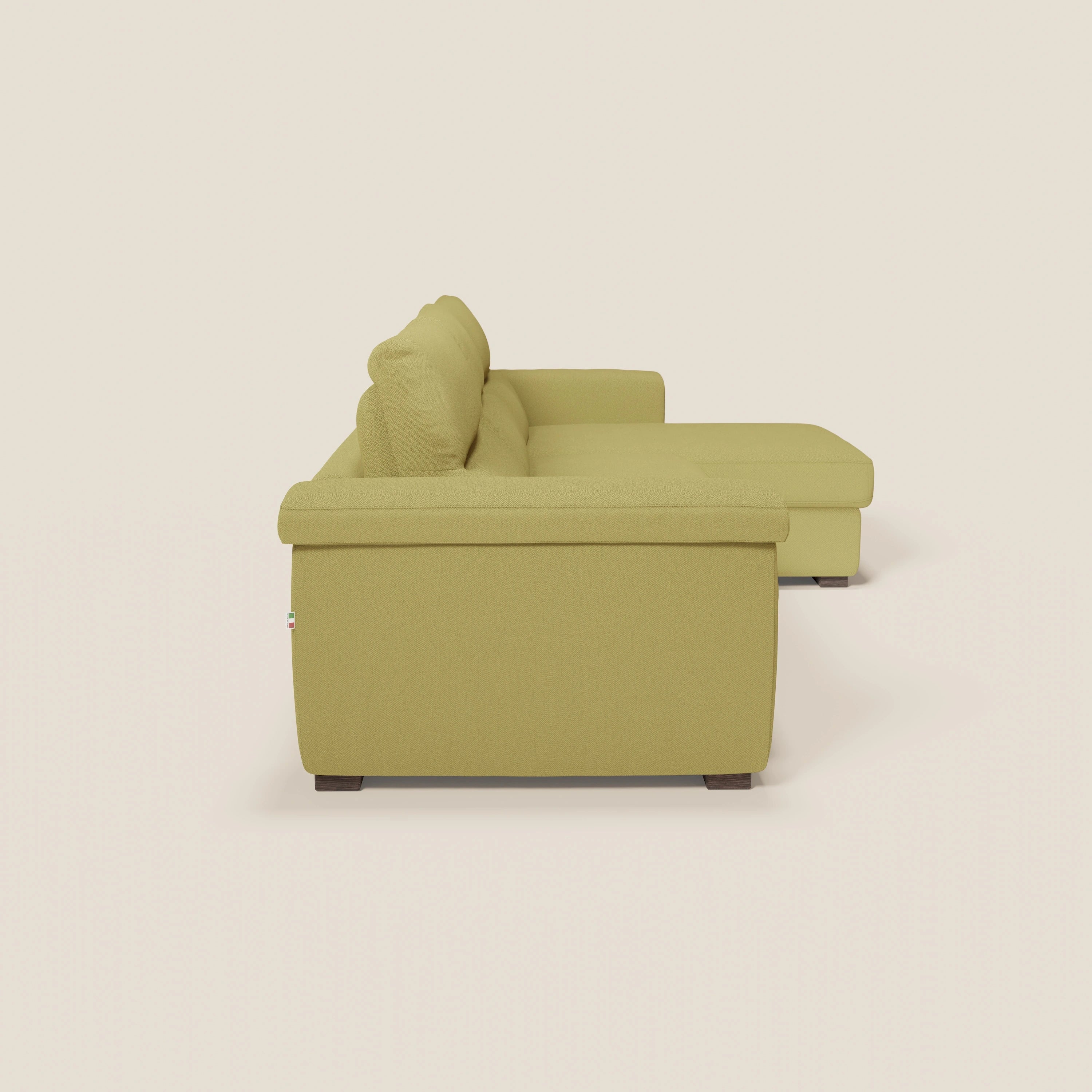 Il divano letto angolare Magnolia con Penisola Contenitore di Divani.Store in smacchiabile T05 giallo è rappresentato da sinistra, con cuscini in feltro, chaise lounge a destra, gambe corte in legno scuro e materasso H18 cm su sfondo bianco sporco.