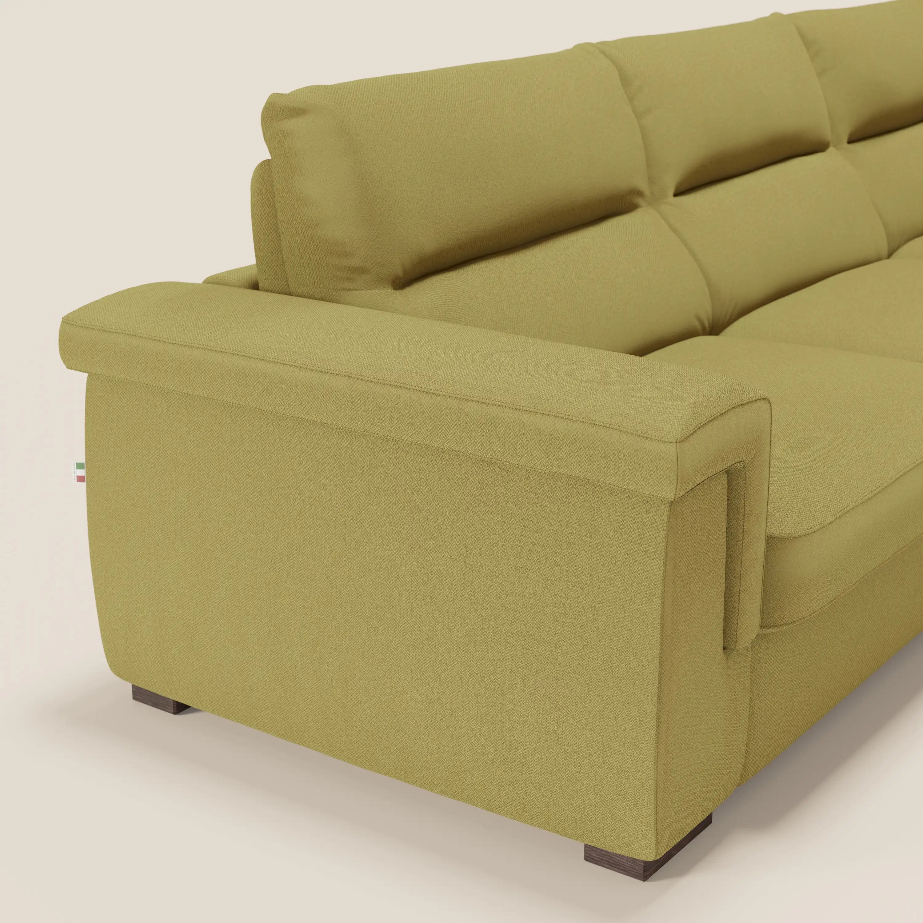 Primo piano dello schienale e del fianco del moderno divano letto angolare Magnolia con Penisola Contenitore di Divani.Store, presentato in tessuto smacchiabile T05 giallo con cuscini in feltro, ampi braccioli, piedini in legno scuro e un'etichetta di tessuto visibile vicino alla base.