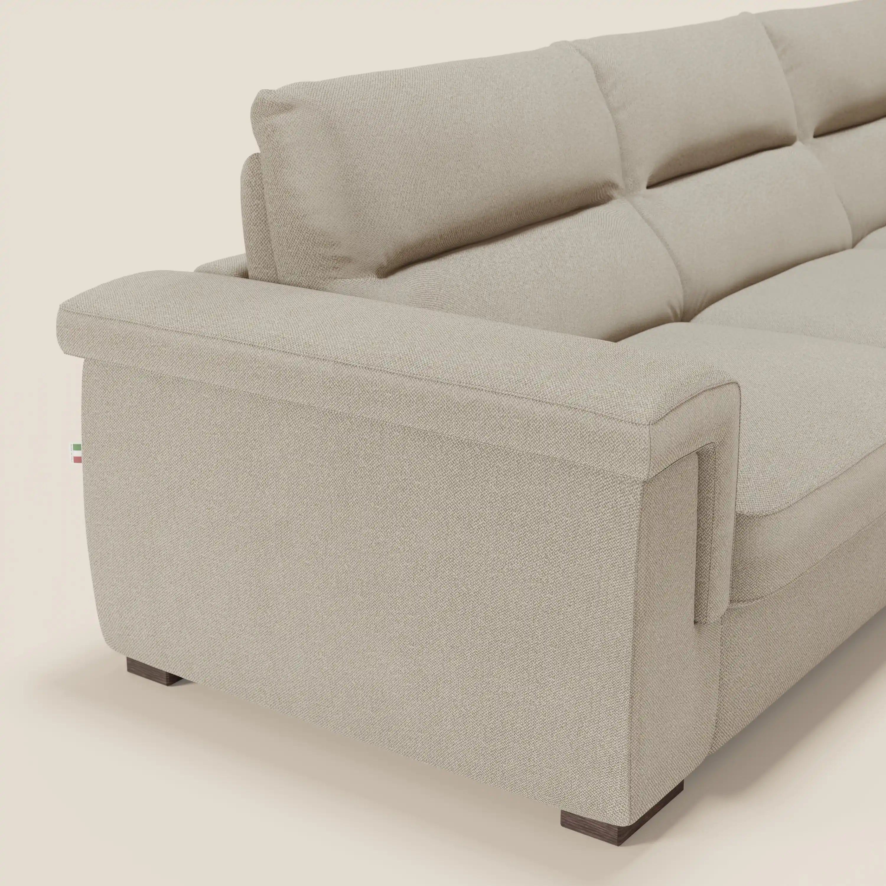 Il Magnolia Divano Letto Angolare di Divani.Store è caratterizzato da un tessuto antimacchia T05 beige chiaro, braccioli imbottiti, cuscini dello schienale con inserti in peluche, linee pulite, gambe scure, targhetta con bandiera italiana e chaise longue con contenitore. Materasso H18 cm. Sfondo bianco sporco.