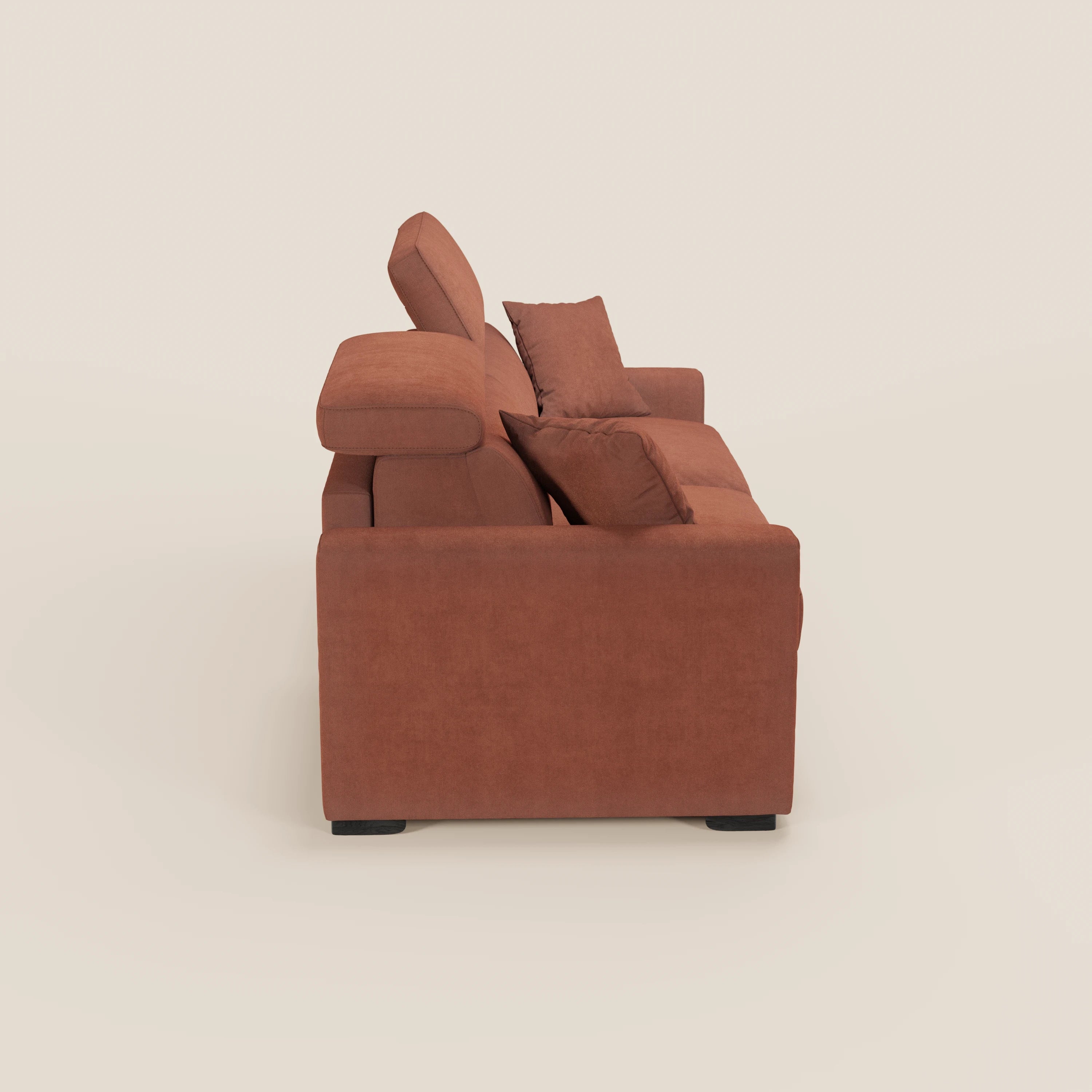 Vista laterale del divano letto Maximus a 3 posti con materasso ALTO 20 cm di Divani.Store, in tessuto smacchiabile Oeko-Tex color marrone, con due cuscini, poggiatesta reclinabili, ampi braccioli e gambe a blocco nere su sfondo bianco sporco.