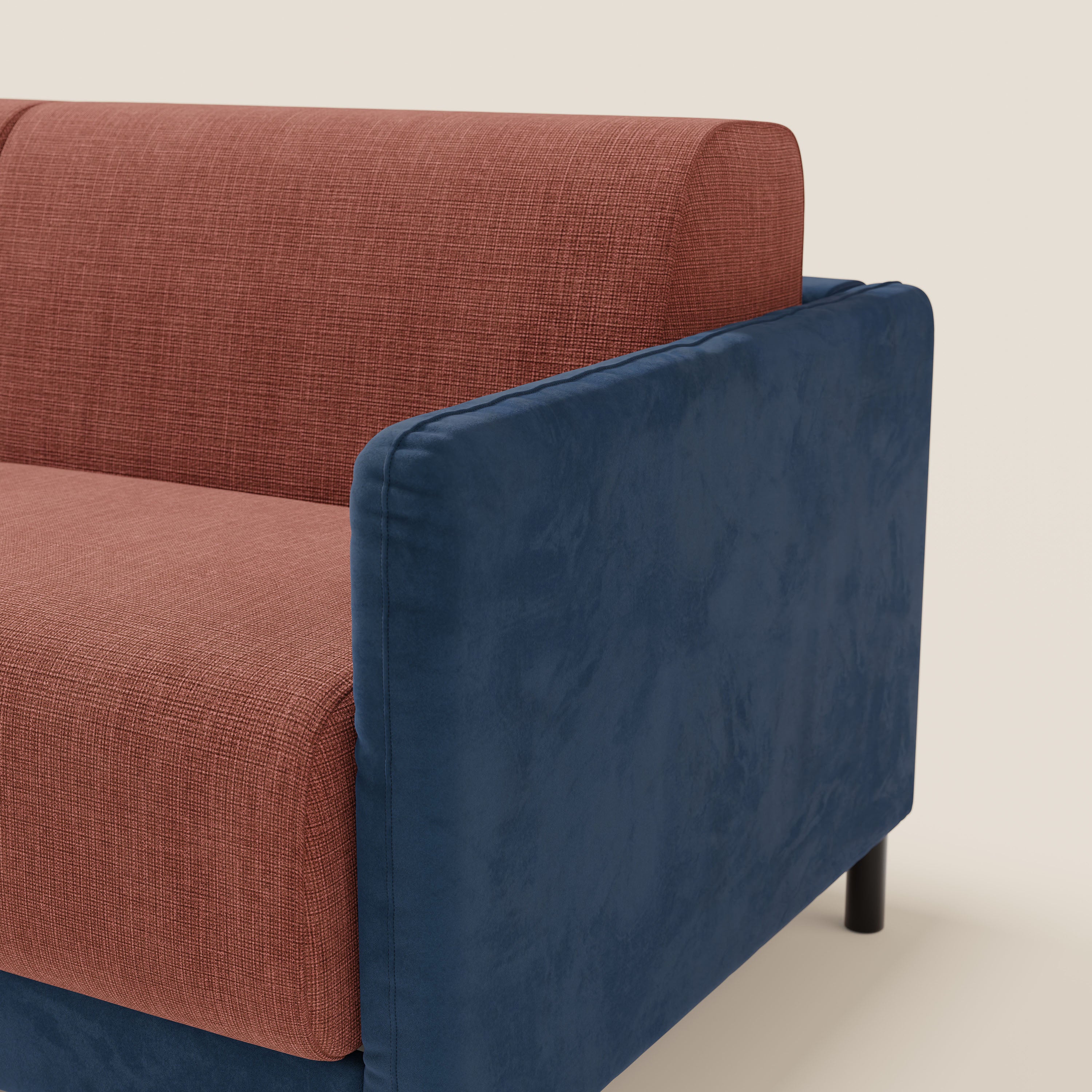 Il divano letto Narciso di Divani.Store è caratterizzato da seduta e schienale in tessuto impermeabile T06 color ruggine-corallo, bracciolo in microfibra liscia blu navy, gambe corte nere e materasso H18 cm, su sfondo beige chiaro.