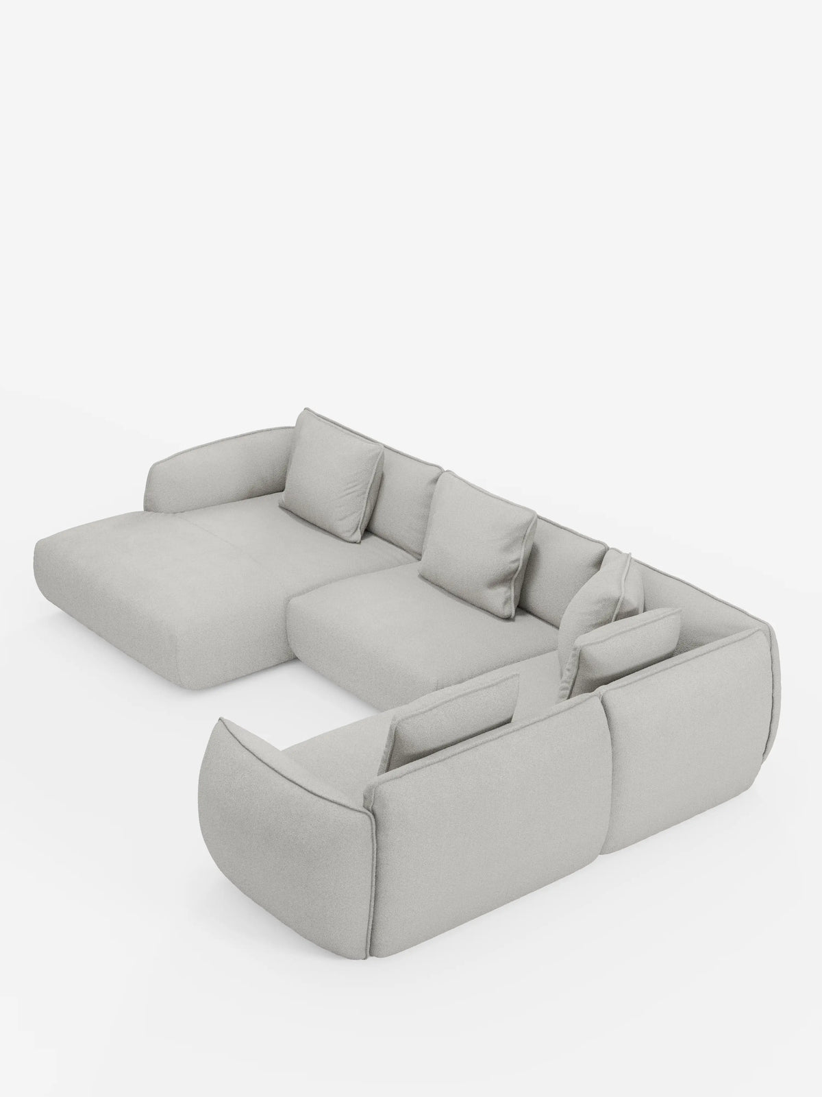 Divano angolare panoramico componibile Nimbus con penisola e angolo in tessuto antimacchia T33 di Divani.Store, qui presentato in una finitura grigio chiaro con morbidi cuscini e braccioli bassi e larghi. Questo divano moderno e minimalista è dotato di quattro cuscini di seduta e cinque cuscini dello schienale coordinati, il tutto su uno sfondo bianco a tinta unita. Realizzato in Italia, l’elegante divano modulare Nimbus coniuga con naturalezza stile e comfort per gli spazi abitativi contemporanei.