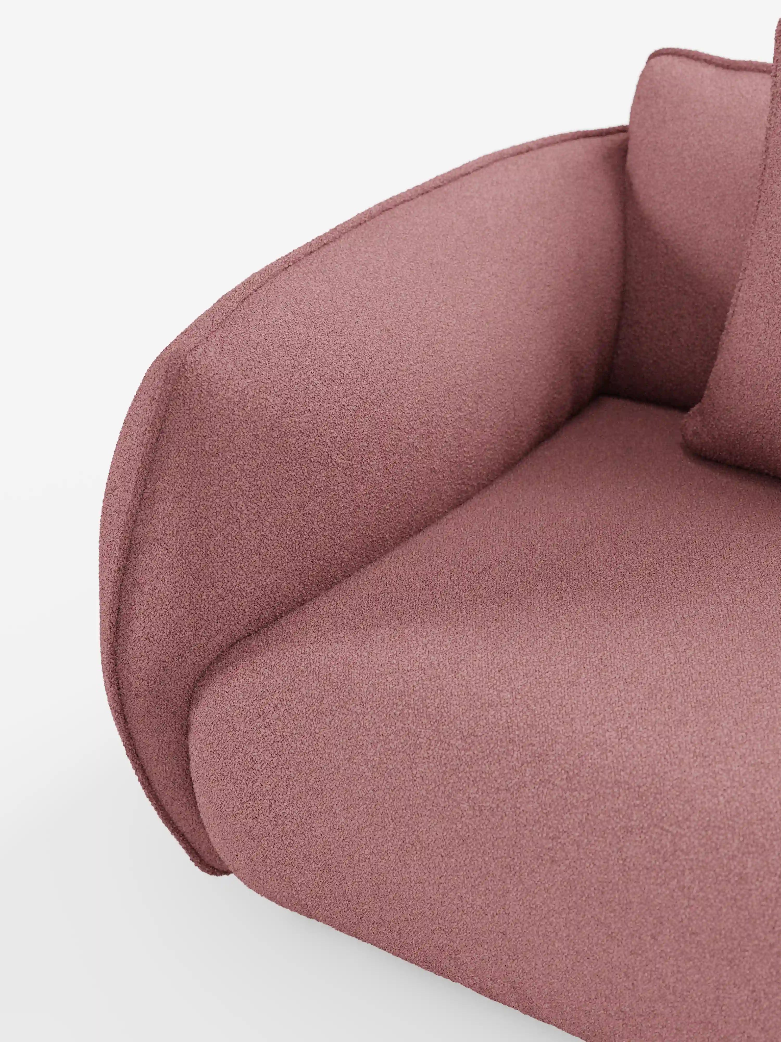 Primo piano del divano modulare e componibile Nimbus a 3 posti (250 cm) di Divani.Il modello, caratterizzato da morbidi braccioli arrotondati e schienale color malva, è rivestito in tessuto sfoderabile effetto cotone antimacchia (t33); un cuscino coordinato è parzialmente visibile su uno sfondo bianco a tinta unita, mettendo in risalto le morbide curve del divano e il suo invitante comfort.