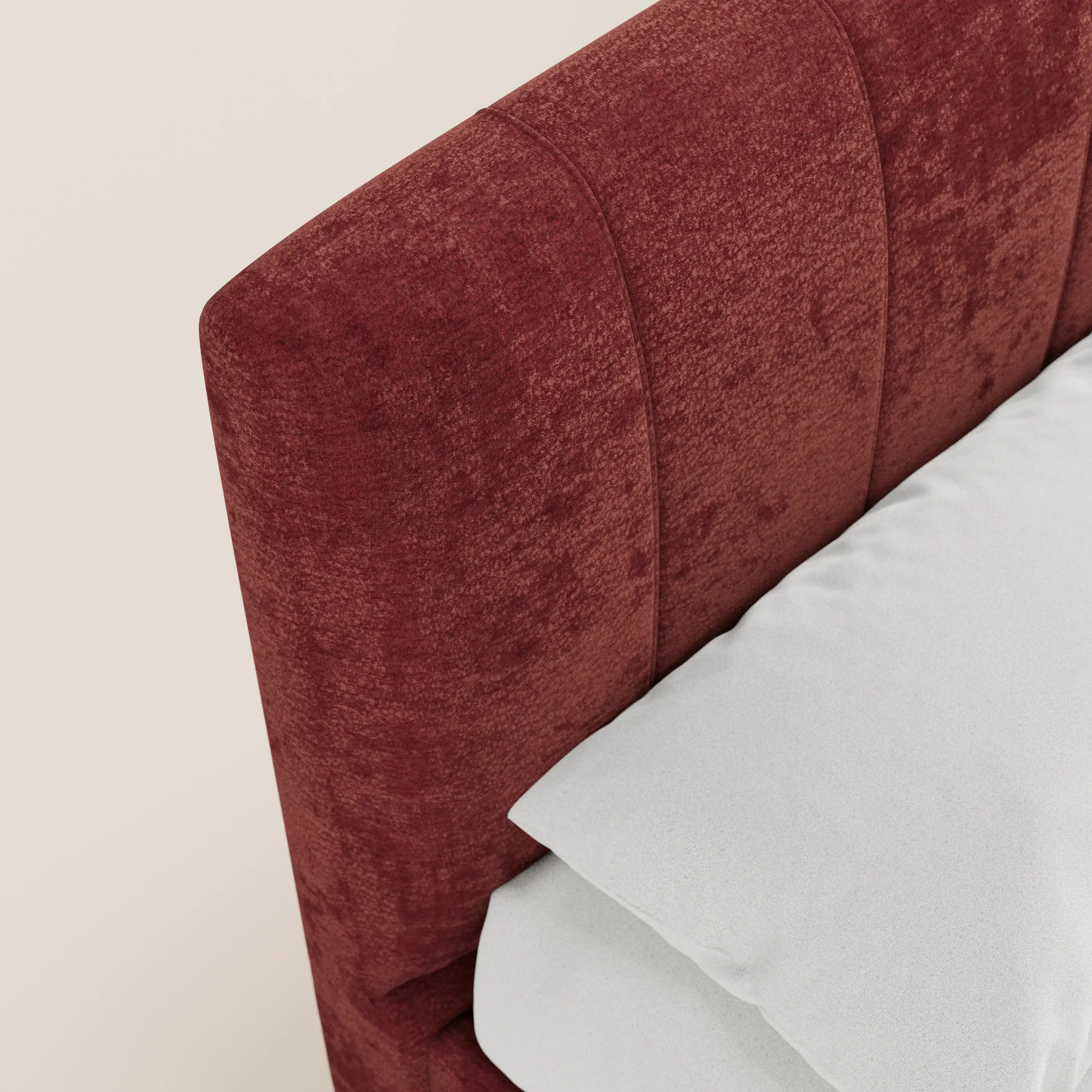 Primo piano del letto imbottito ONYX con contenitore e testiera verticale in tessuto certificato Oeko-Tex® di Letti.store. La testiera rosso intenso, impunturata verticalmente, contrasta con un cuscino e un lenzuolo di un bianco brillante su uno sfondo neutro.