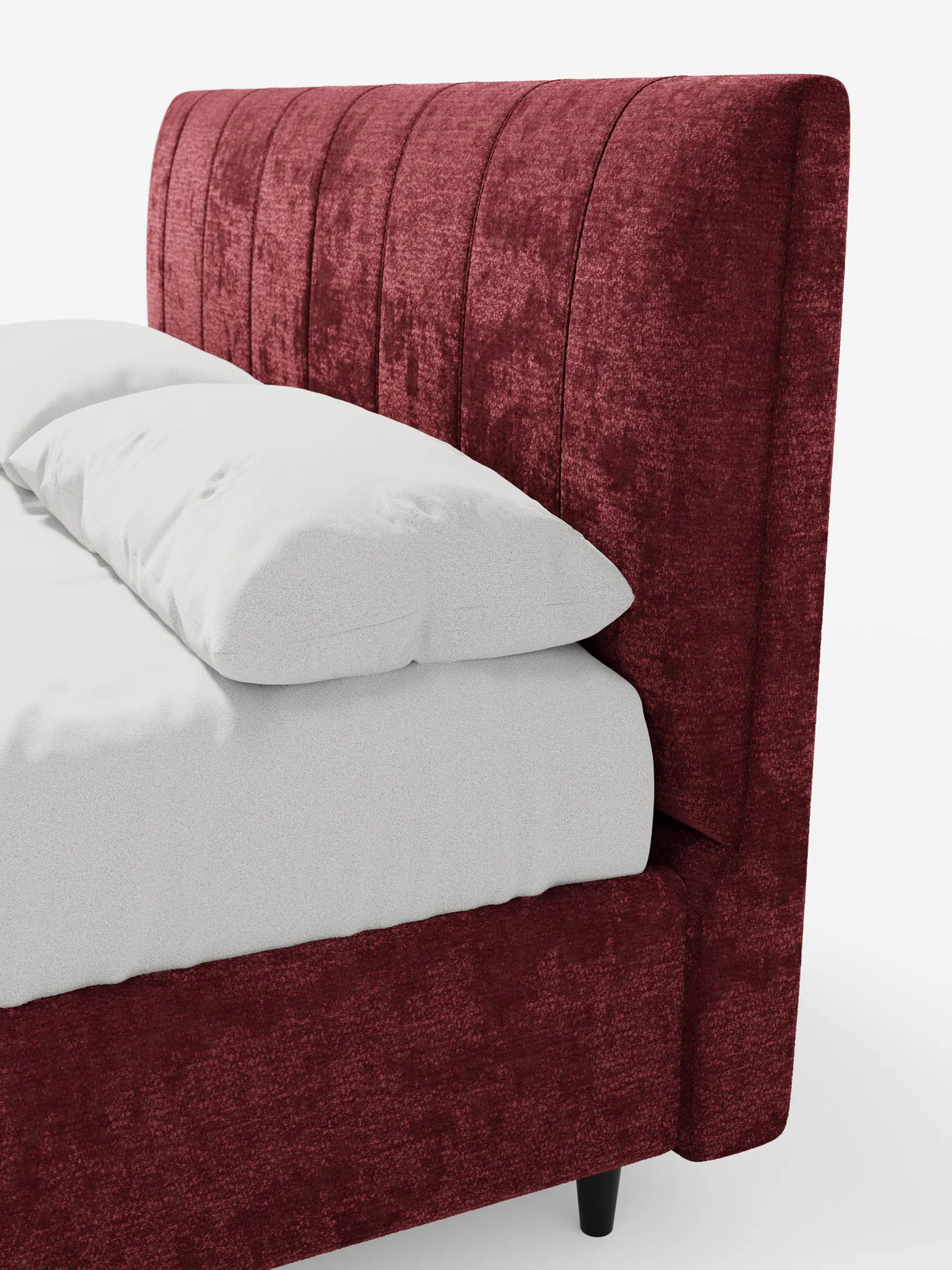 Un primo piano del letto imbottito ONYX con contenitore e testiera verticale in tessuto certificato Oeko-Tex®, caratterizzato da una testiera imbottita di colore rosso intenso con cuciture verticali, rivestito con lenzuola bianche su uno sfondo chiaro.
