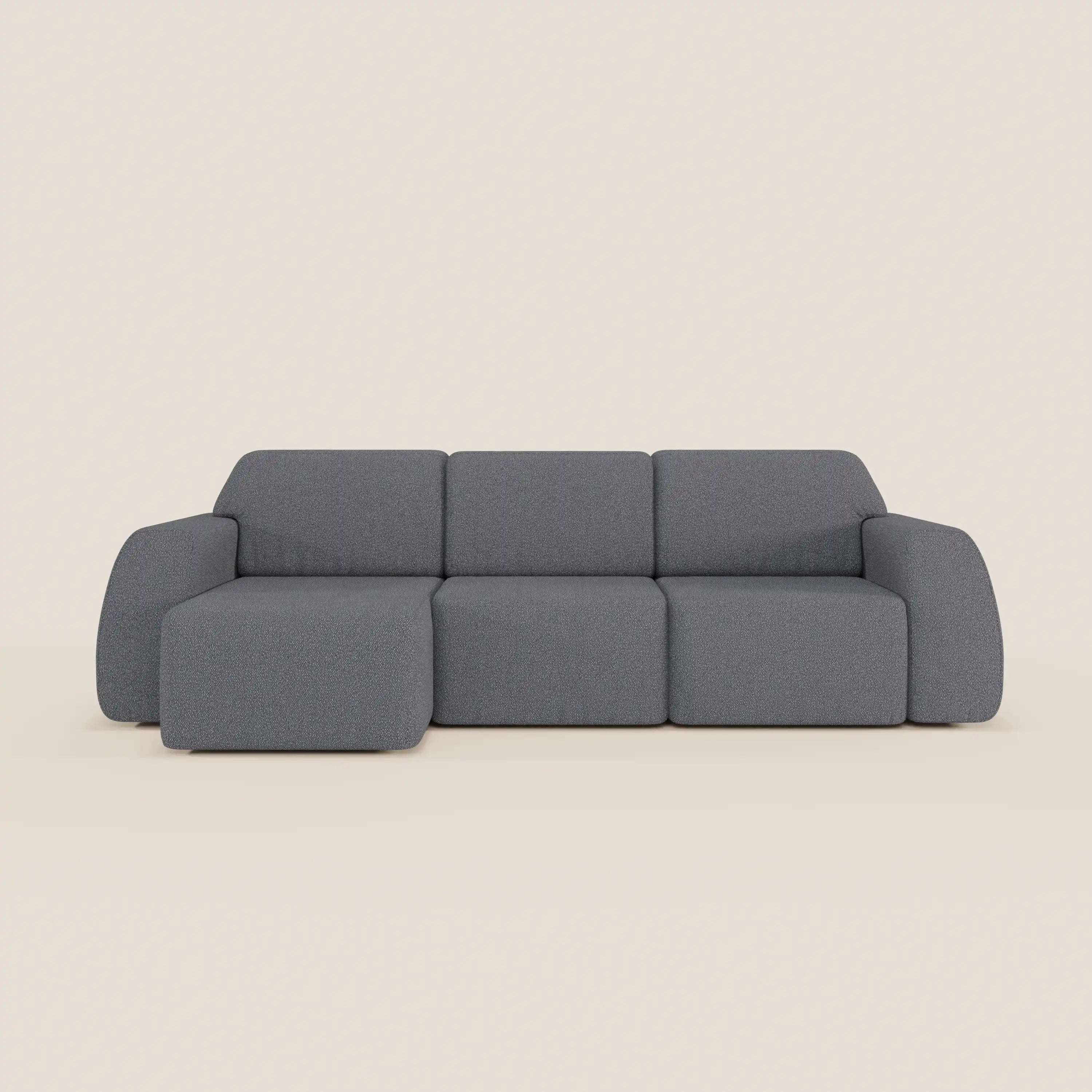 Orbit Divano angolare con penisola reversibile di Divani.Store è caratterizzato da sedute allungabili, tre cuscini e braccioli ampi e arrotondati in un tessuto antimacchia effetto cotone T33, il cui design elegante e grigio spicca su uno sfondo beige chiaro.