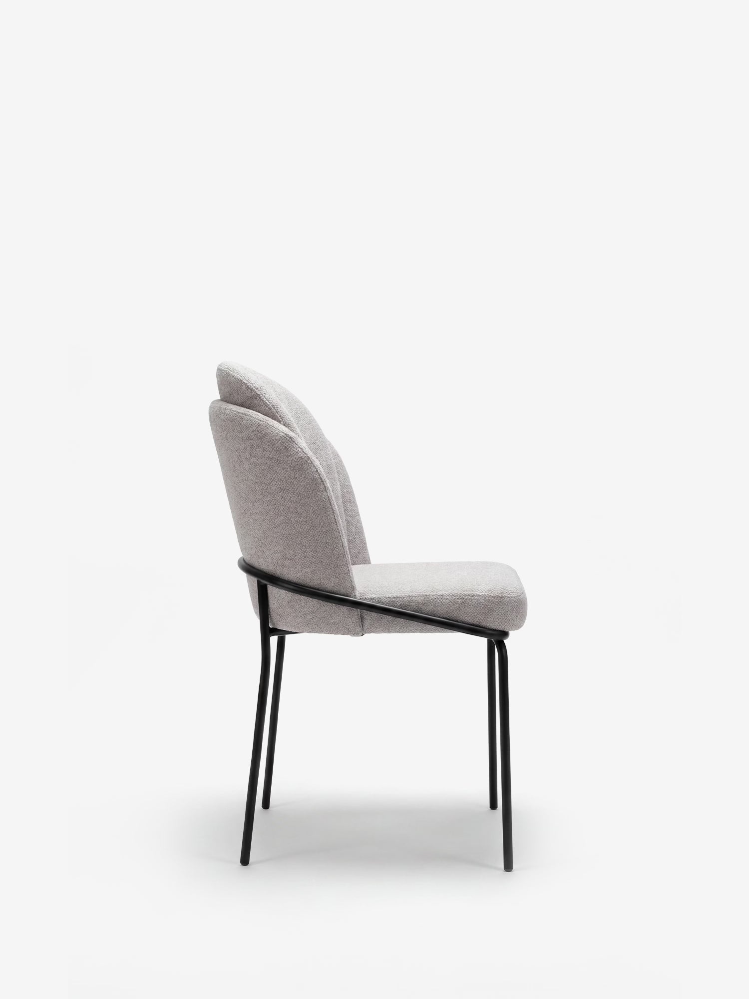 La sedia imbottita Plissè di Divani.Store presenta una seduta rivestita in tessuto impermeabile grigio chiaro, uno schienale in stile plissé e sottili gambe in metallo nero. Immagine di profilo in stile minimalista su sfondo bianco.