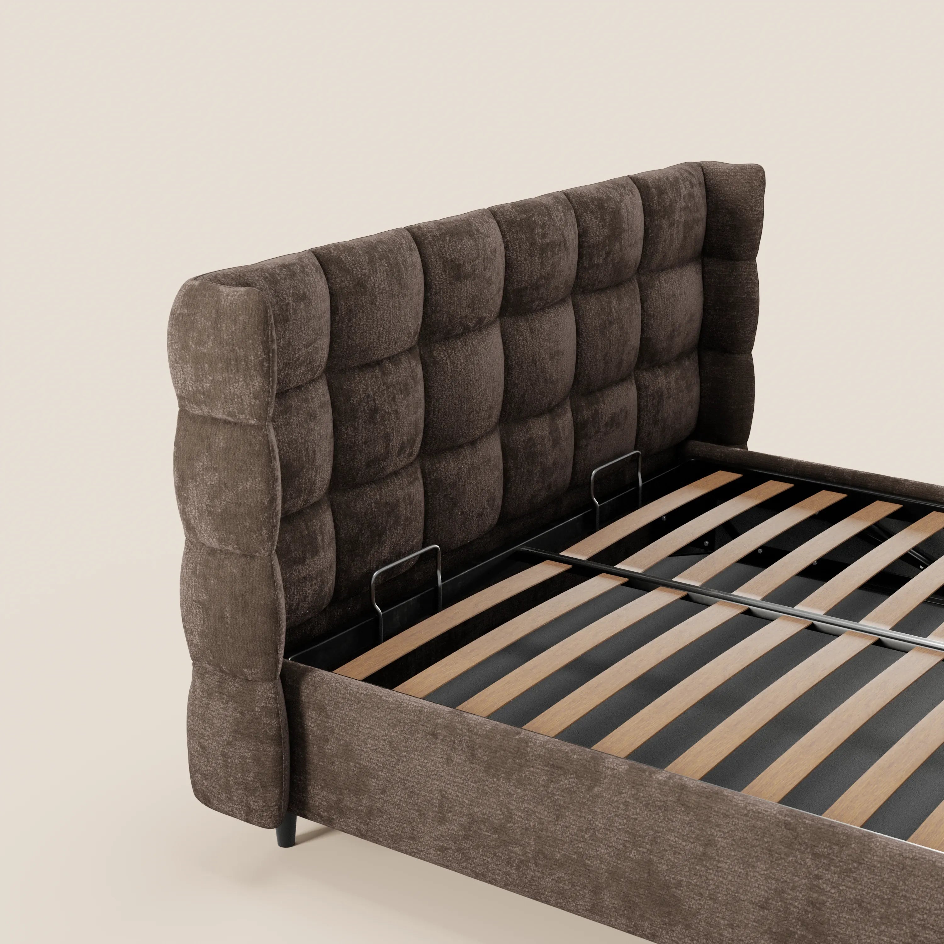 Un primo piano del letto imbottito RAGNAR di Letti.store, caratterizzato da una testiera avvolgente capitonné in tessuto marrone scuro certificato Oeko-Tex®, doghe in legno, gambe corte e una morbida struttura imbottita, su uno sfondo beige a tinta unita.