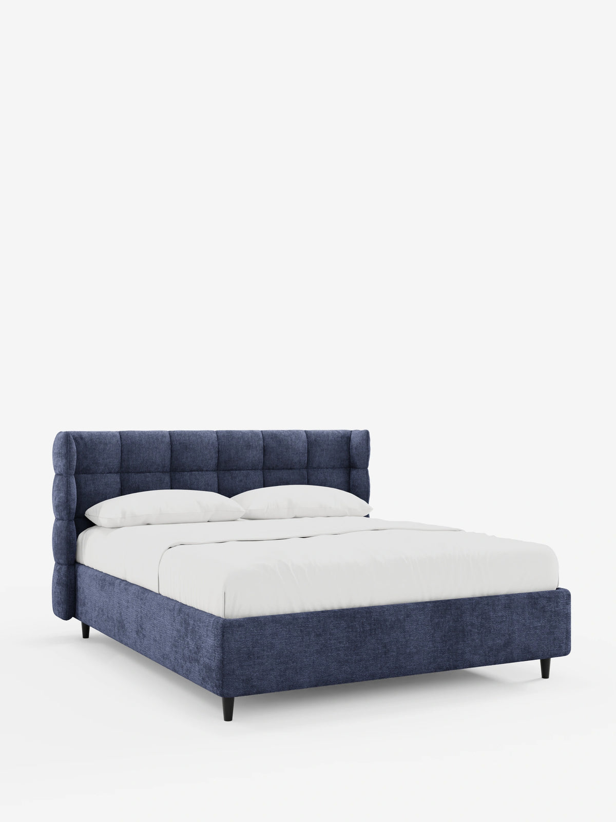 Il letto imbottito RAGNAR con contenitore e testiera capitonné avvolgente è un letto matrimoniale blu navy con una testiera alta, capitonné e avvolgente, biancheria da letto di un bianco candido e gambe corte, scure e affusolate che risaltano sullo sfondo bianco.