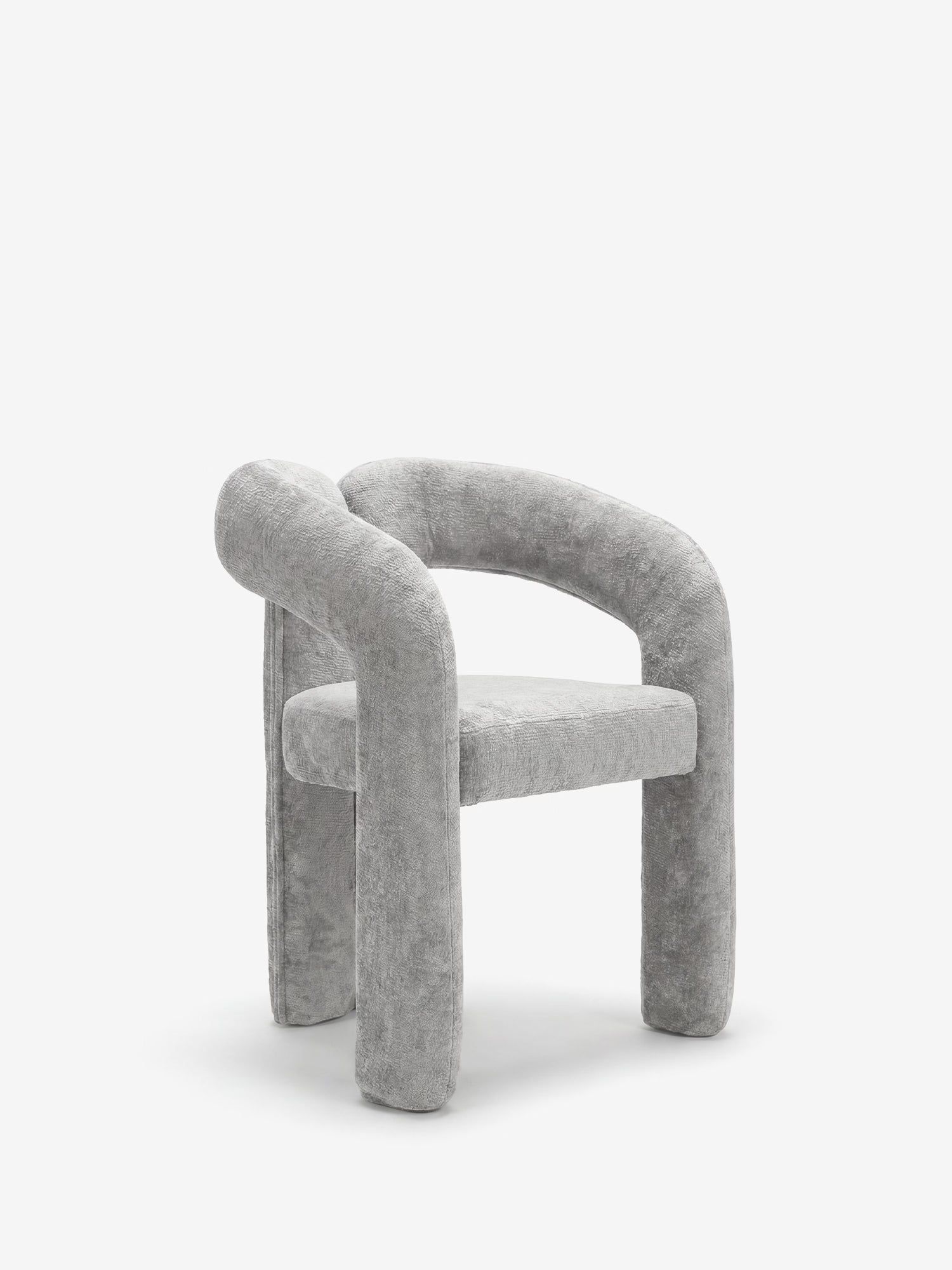 La sedia di design Sibilla di Divani.Store presenta braccioli e gambe spessi e arrotondati, interamente rivestiti in tessuto grigio chiaro. La sua forma ad arco, minimalista e scultorea, dona un tocco di modernità agli spazi contemporanei.
