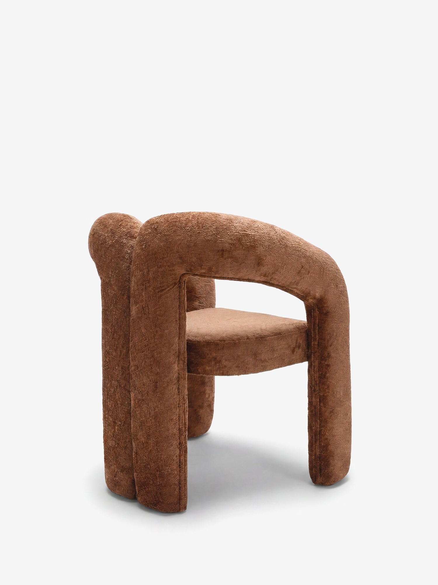 La Sibilla, sedia di design imbottita di Divani.Store, presenta una moderna forma arcuata, un tessuto dalla trama morbida, braccioli spessi e arrotondati e gambe cilindriche, il tutto interamente rivestito in marrone, come si vede nella foto su sfondo bianco.