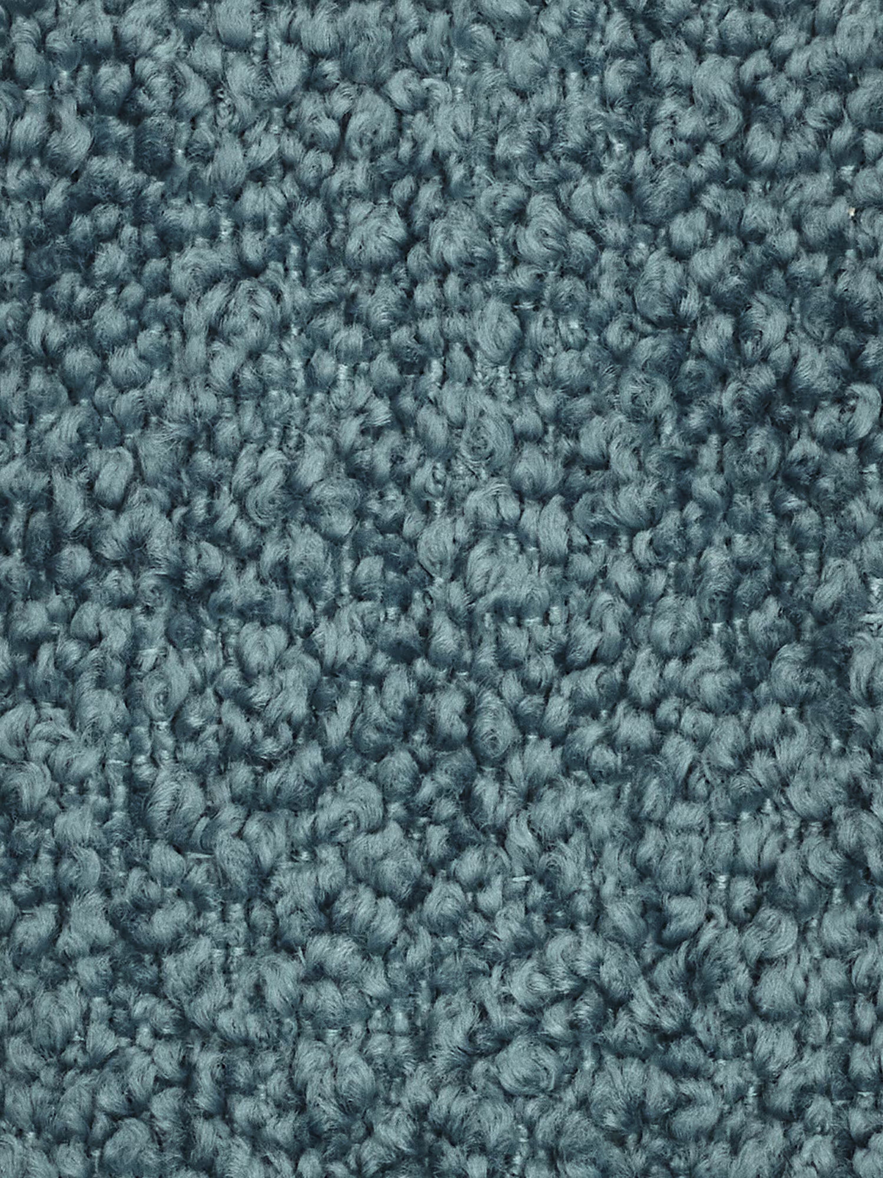 Primo piano di un tappeto a riccioli blu, che mostra fibre intrecciate a trama fitta e strutturate che creano una superficie morbida e irregolare. I filati sono uniformi per dimensioni e colore, conferendo al tappeto un aspetto soffice e omogeneo con una delicata lucentezza: una base ideale per disporre un divano modulare o qualsiasi elemento centrale di un soggiorno moderno. Nessuna macchia o segno di usura visibile.