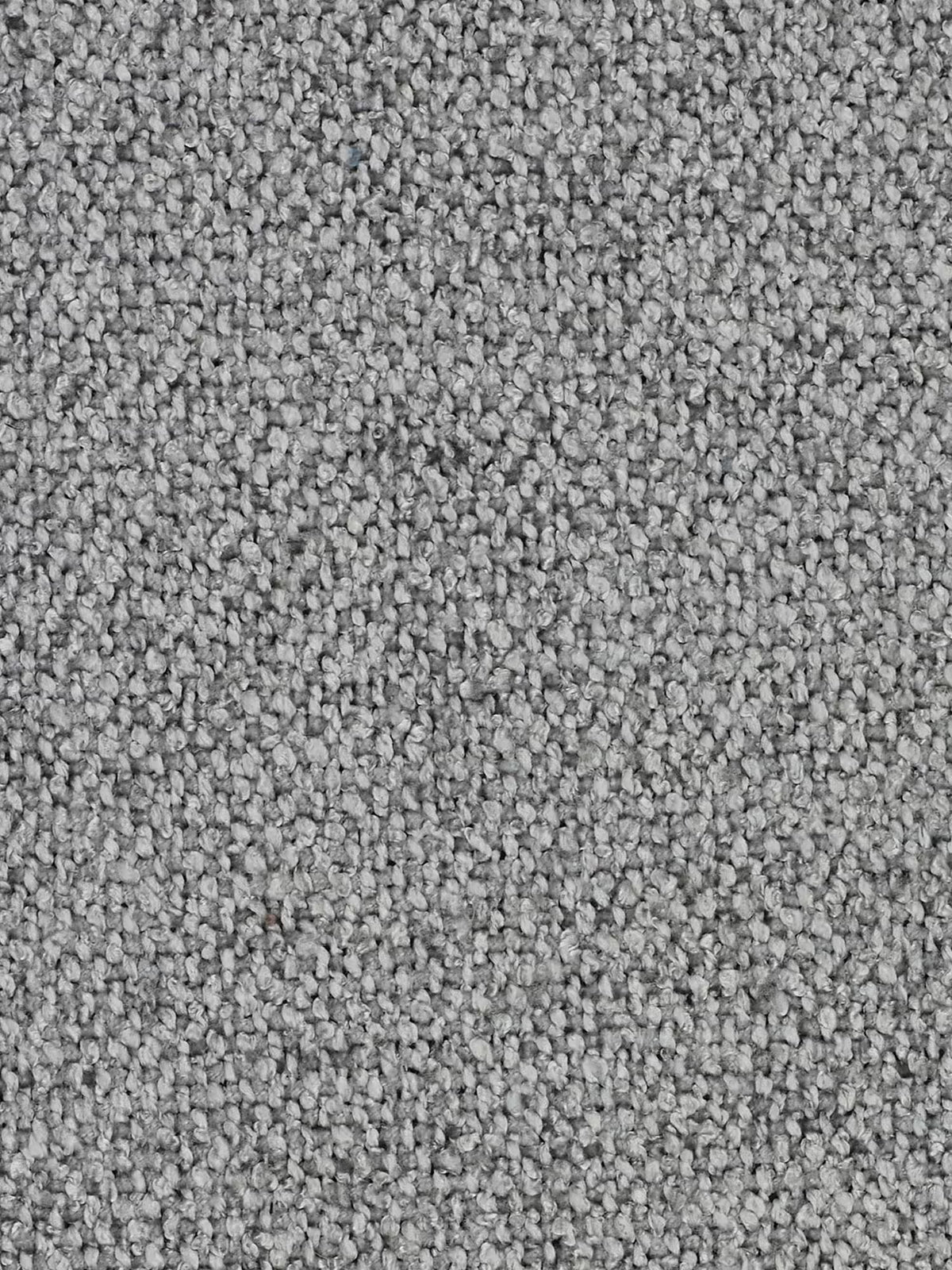 Primo piano di un tappeto grigio caratterizzato da un pelo testurizzato a riccioli fitti. Le fibre di dimensioni uniformi, nei toni tenui, creano un effetto morbido e screziato: un eccellente complemento al divano modulare a 3 posti Nimbus, componibile in morbido tessuto smacchiabile effetto cotone T33 di Divani.Da utilizzare in negozio o per esaltare l’atmosfera accogliente del vostro soggiorno. Un’illuminazione soffusa mette in risalto le sfumature che si intrecciano sulla superficie del tessuto.