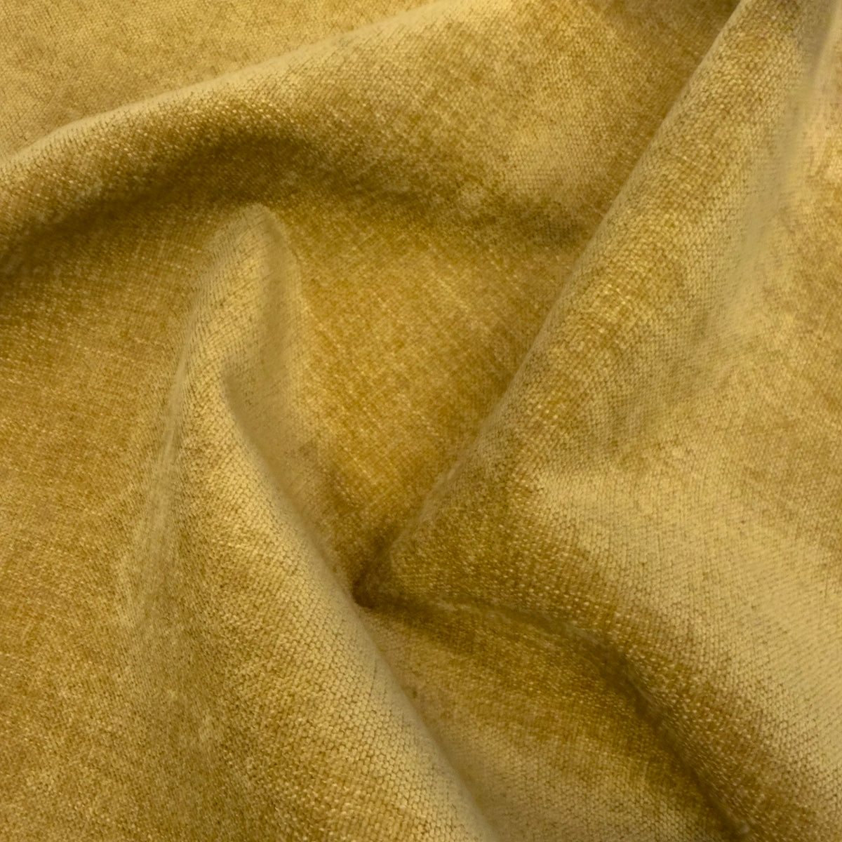 Tessuto T41 PASSEPARTOUT giallo senape, misto lino fiammato, adatto agli animali domestici e smacchiabile, con una finitura testurizzata effetto lino, arricciato in morbide pieghe fluide che creano giochi di luce e ombre profonde su tutta la superficie.
