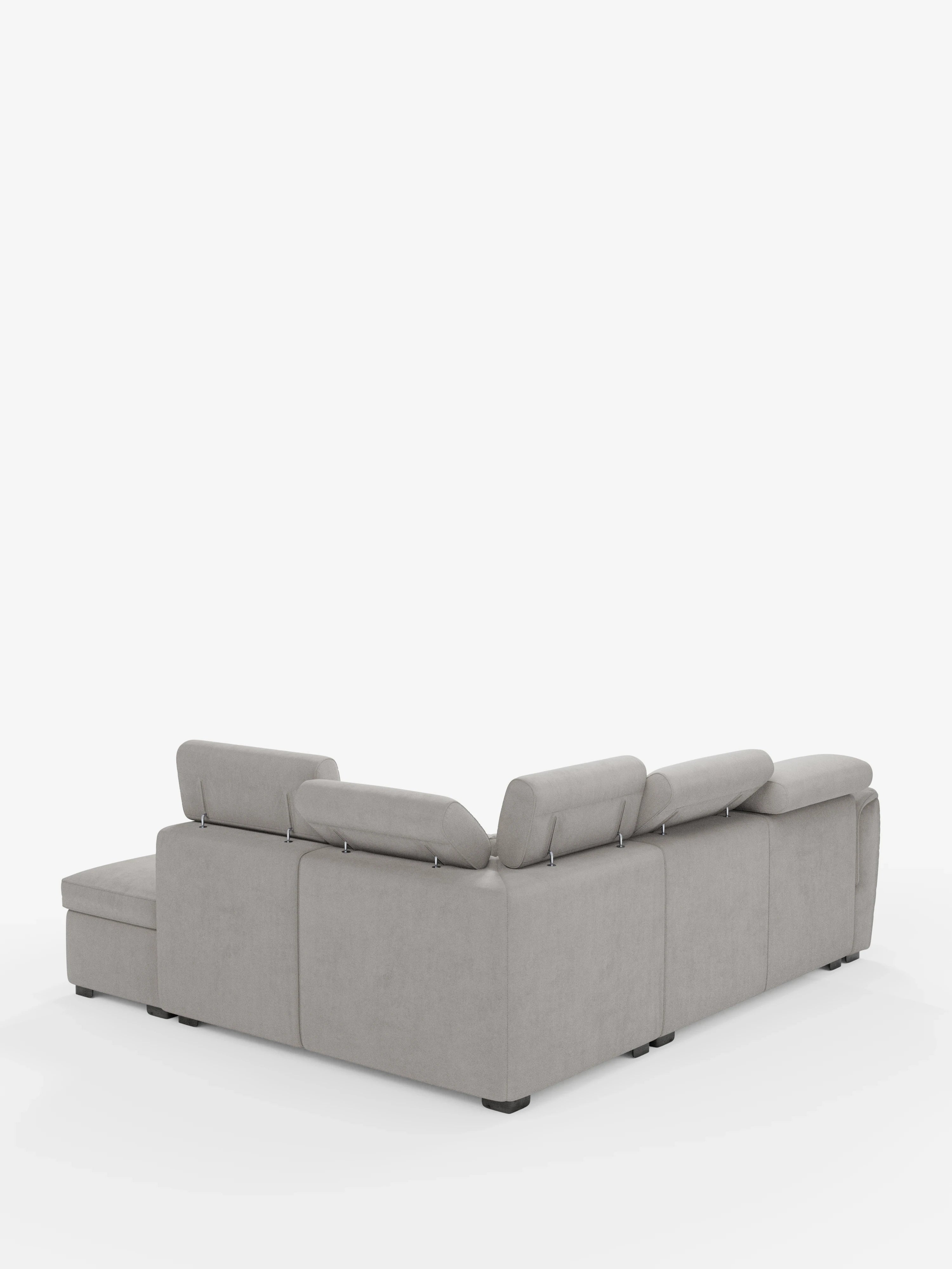 Un divano angolare reversibile Titano grigio chiaro con seduta estraibile e pouf contenitore di Divani.Store, dotato di poggiatesta reclinabili in tessuto antimacchia certificato Oeko-Tex®, è esposto su uno sfondo bianco. Il divano componibile presenta linee pulite e moderne e piedini neri, con la chaise longue posizionata sul lato sinistro se osservata dall’angolo posteriore.