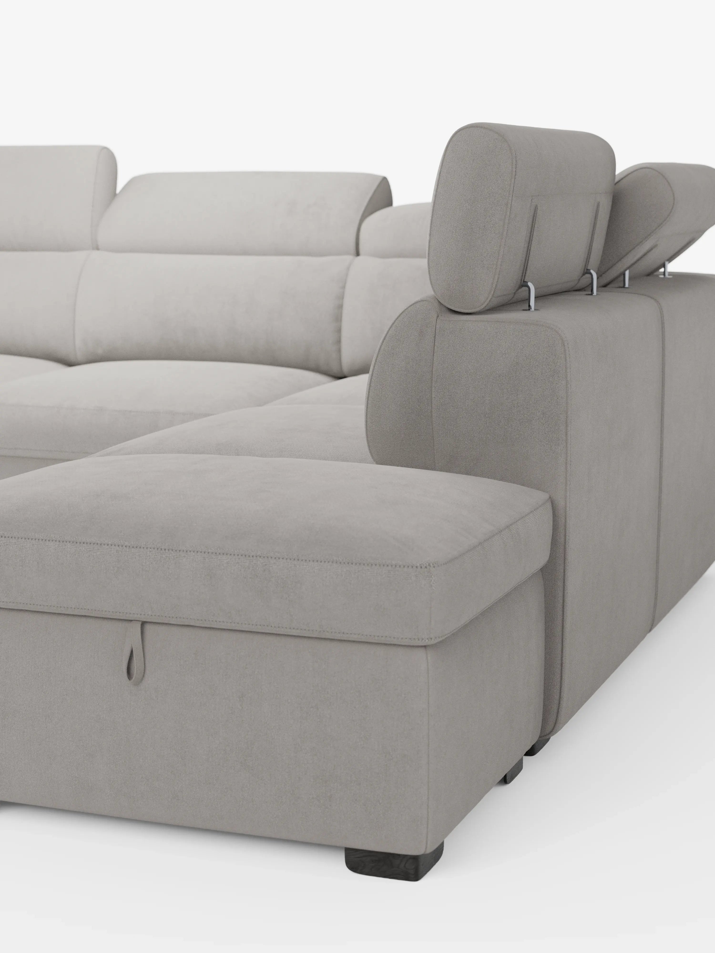 Il divano angolare reversibile Titano con letto estraibile e pouf contenitore di Divani.Store presenta un moderno rivestimento grigio chiaro, resistente alle macchie e certificato Oeko-Tex®, poggiatesta regolabili, una sezione chaise longue con vano contenitore a vista sotto il pouf, ed è sostenuto da corte gambe nere su uno sfondo bianco a tinta unita.