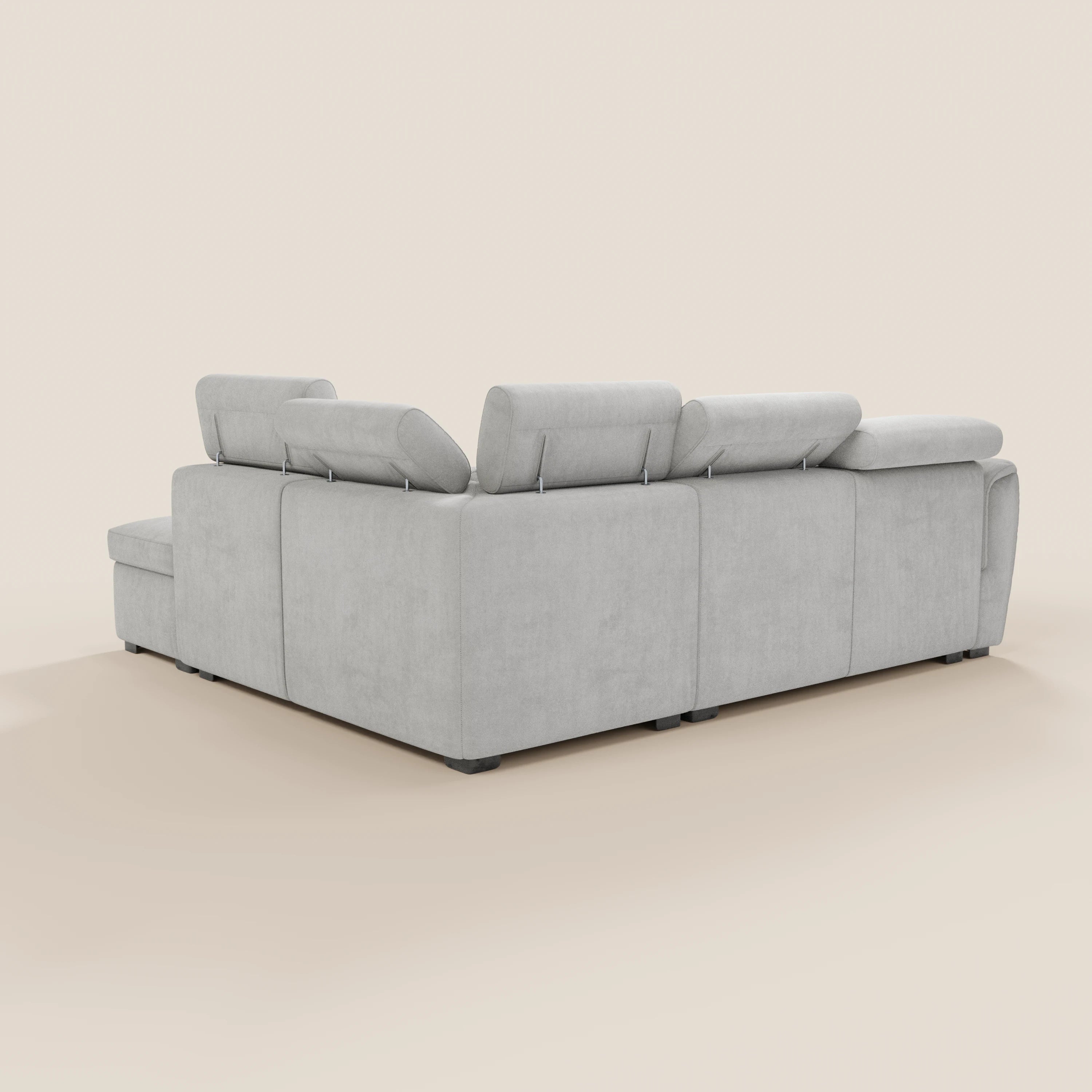 Il divano angolare reversibile Titano di Divani.Store, in tessuto smacchiabile Oeko-Tex®, con poggiatesta reclinabili, contenitore estraibile e pouf contenitore, è raffigurato in grigio chiaro su sfondo beige chiaro nella vista posteriore e laterale.